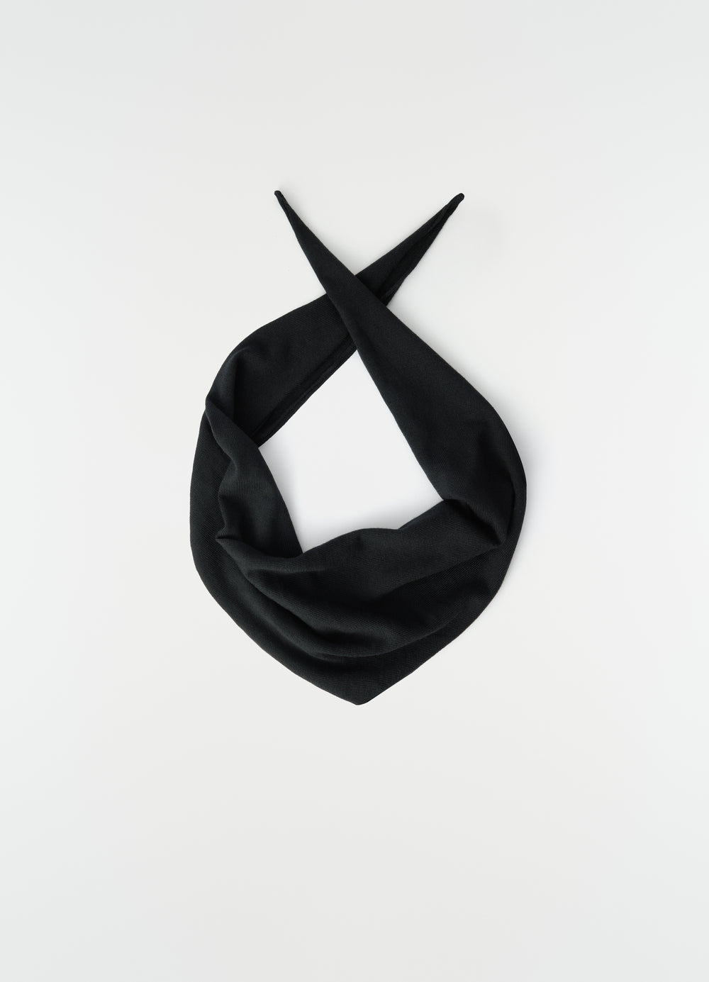 Triangular black merino wool scarf by LEMAIRE laid flat with pointed ends crossed on white background