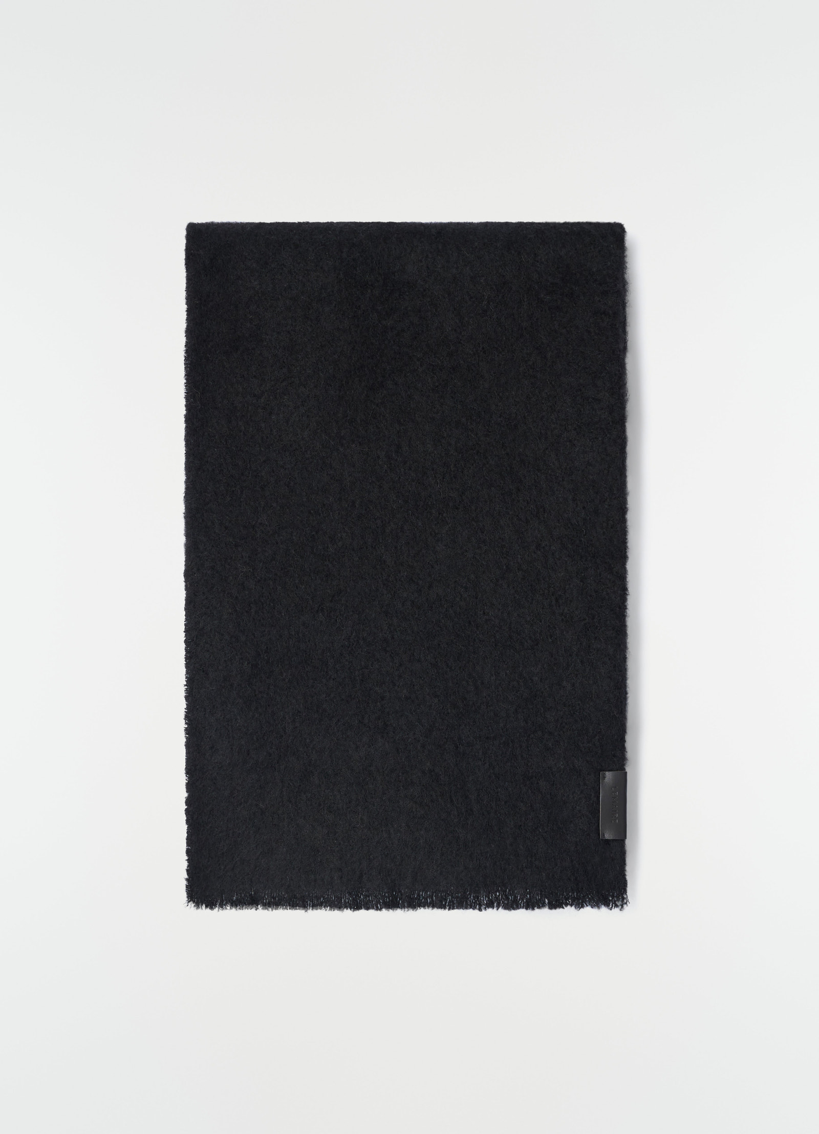 Fluffy black alpaca wool blend scarf by lemaire laid flat with leather logo patch detail on white background