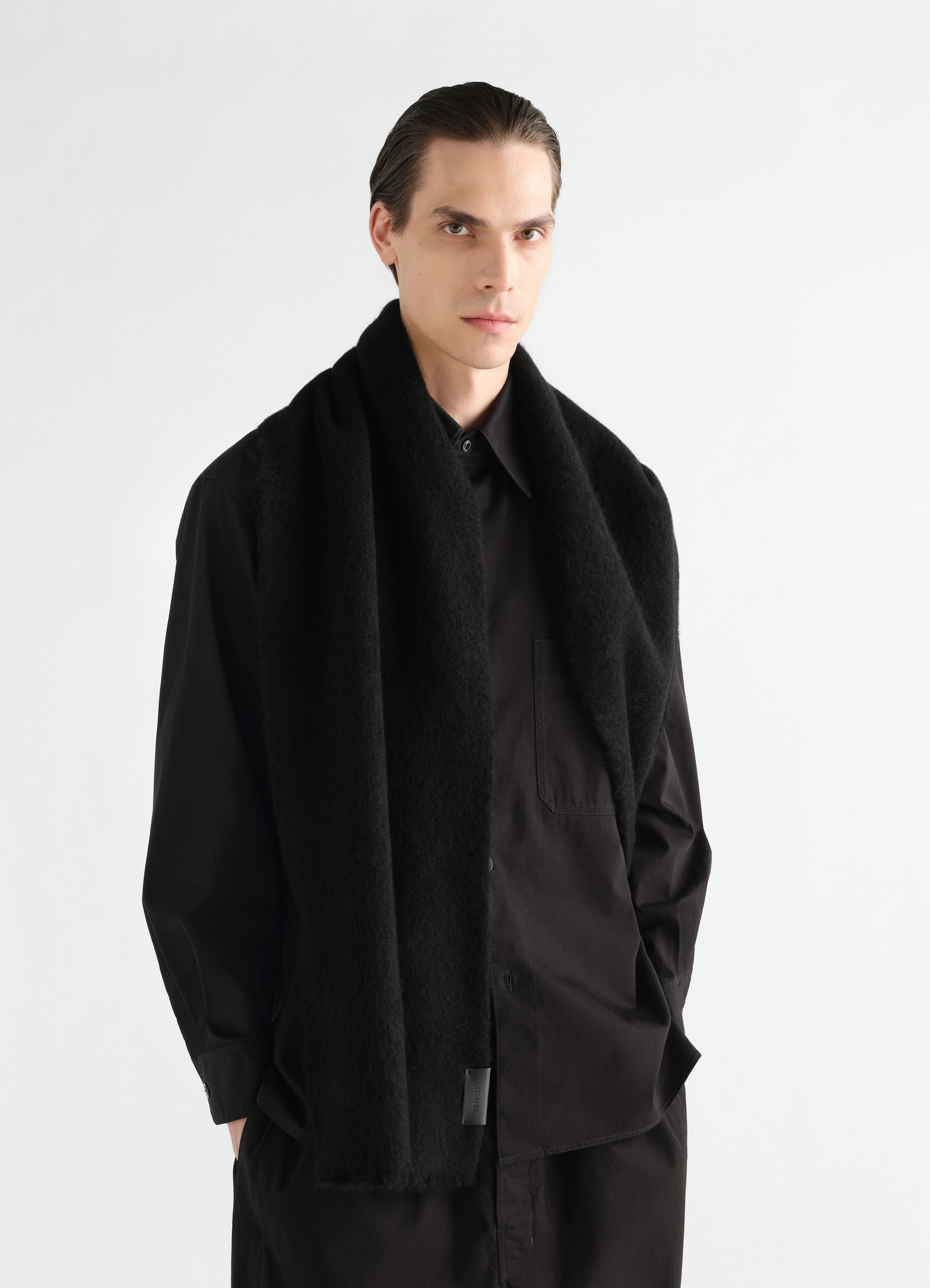 Fluffy black alpaca wool blend scarf lemaire worn by model front view with black shirt and pants