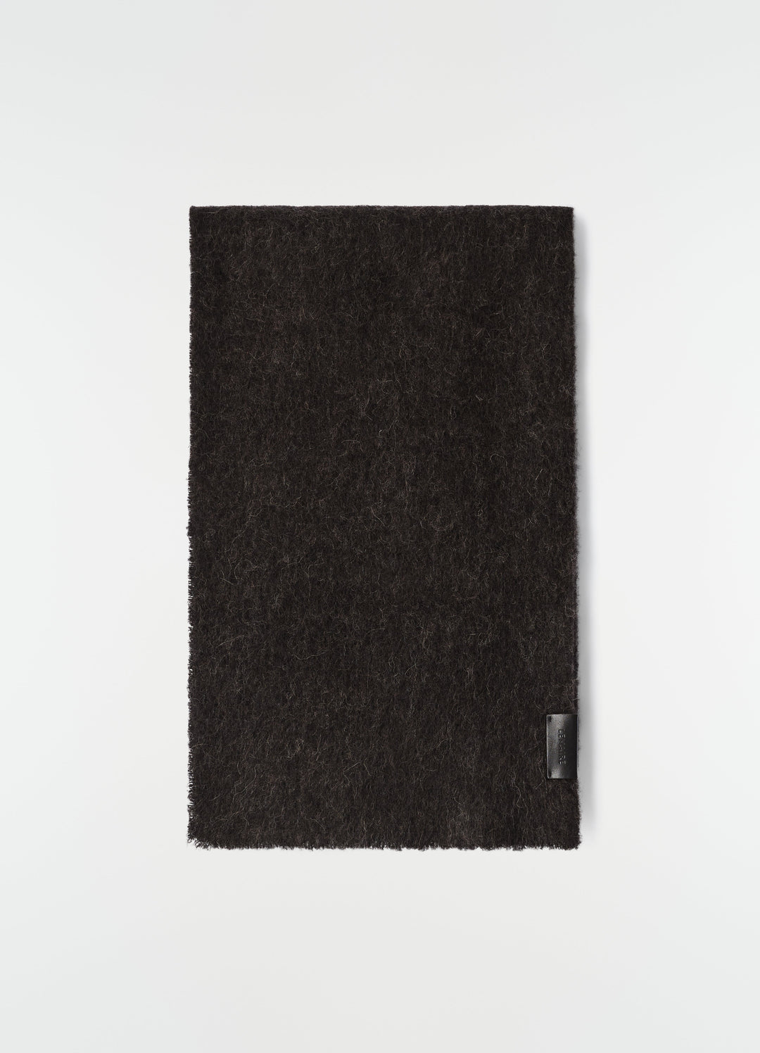 Fluffy black alpaca wool blend scarf by LEMAIRE flat lay with leather logo patch on plain white background