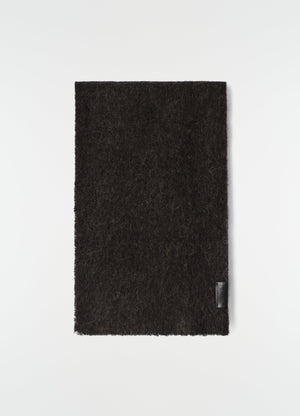 Fluffy black alpaca wool blend scarf by lemaire flat lay with leather logo patch on plain white background