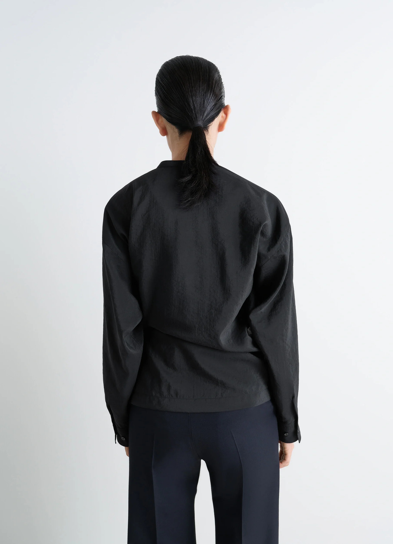 Lemaire twisted top in black dry silk blend, model shot, back view buttoned cuffs and straight hem