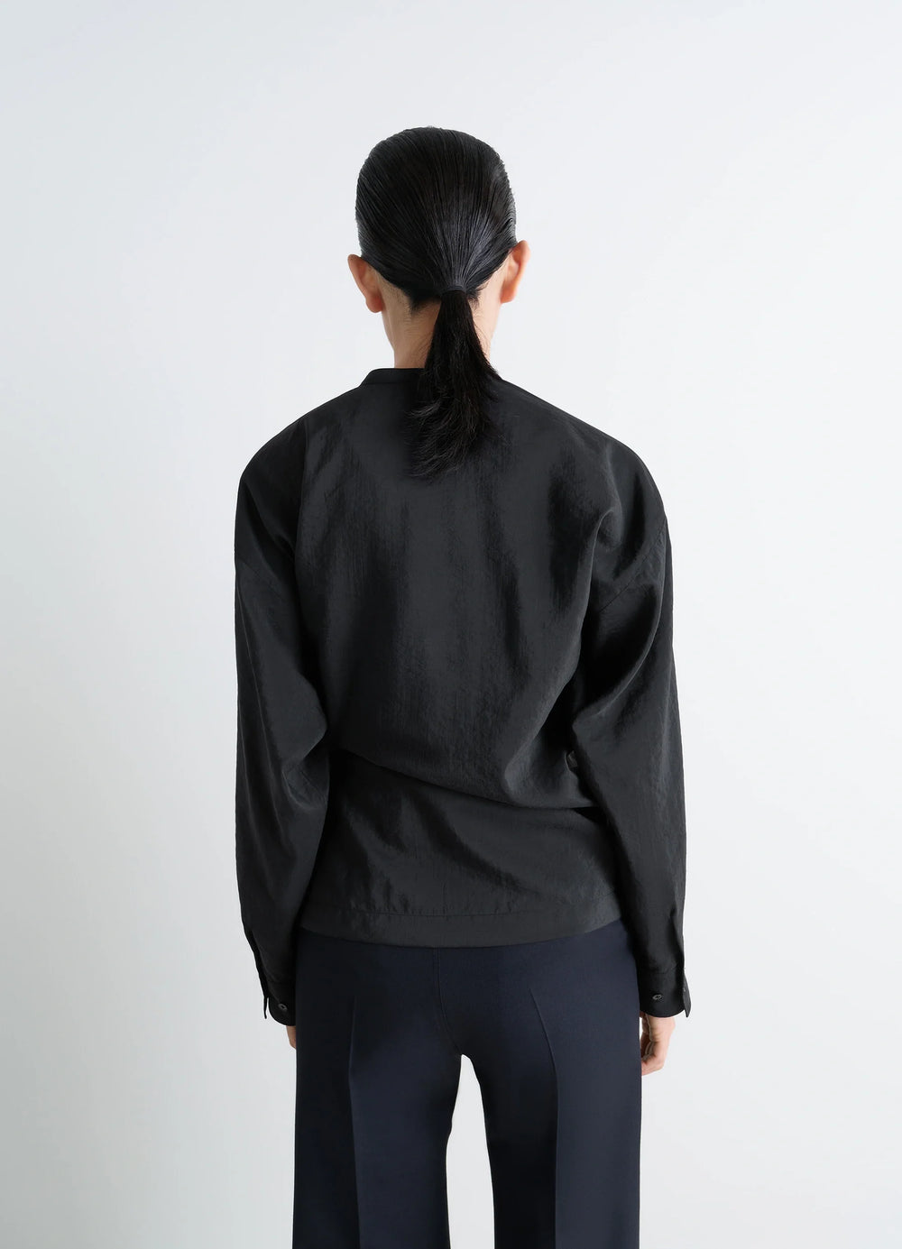 Lemaire Twisted Top in Black Dry Silk Blend, model shot, back view buttoned cuffs and straight hem