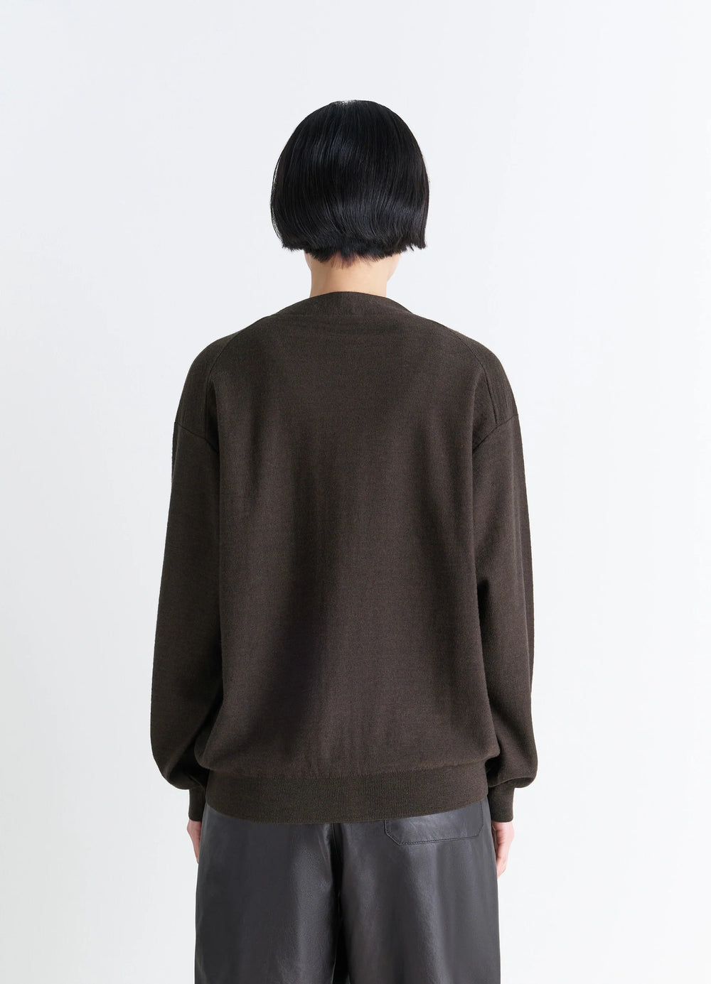 Lemaire Relaxed Twisted Cardigan in Knitted Merino Wool, model shot, back view ribbed hem