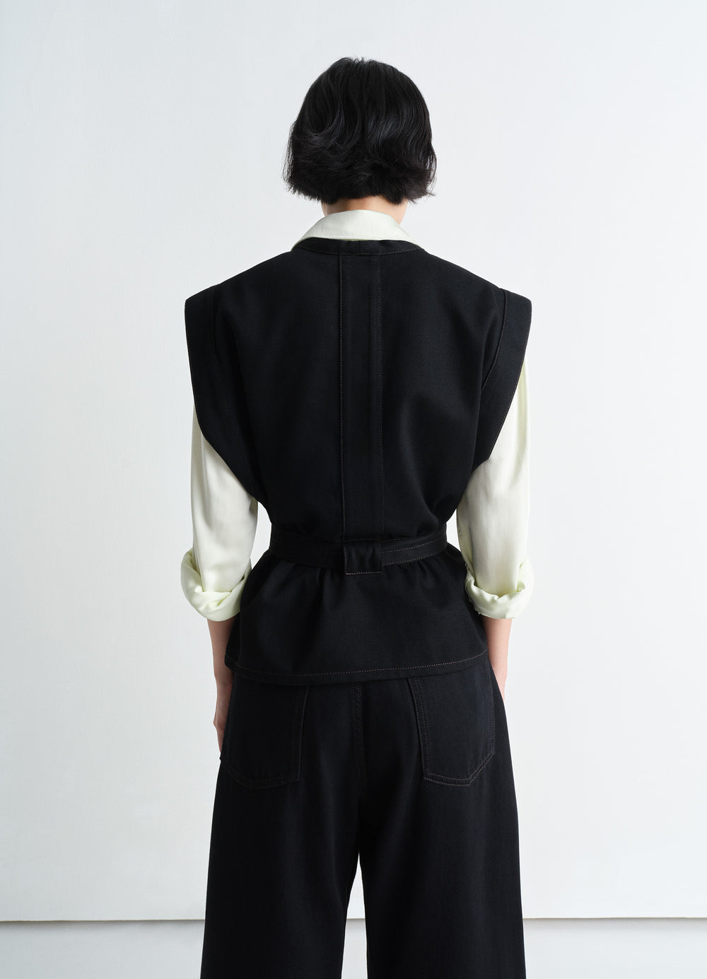 Lemaire Chasuble in Deep Black Twill Denim, model shot, back view belted waist straight cut