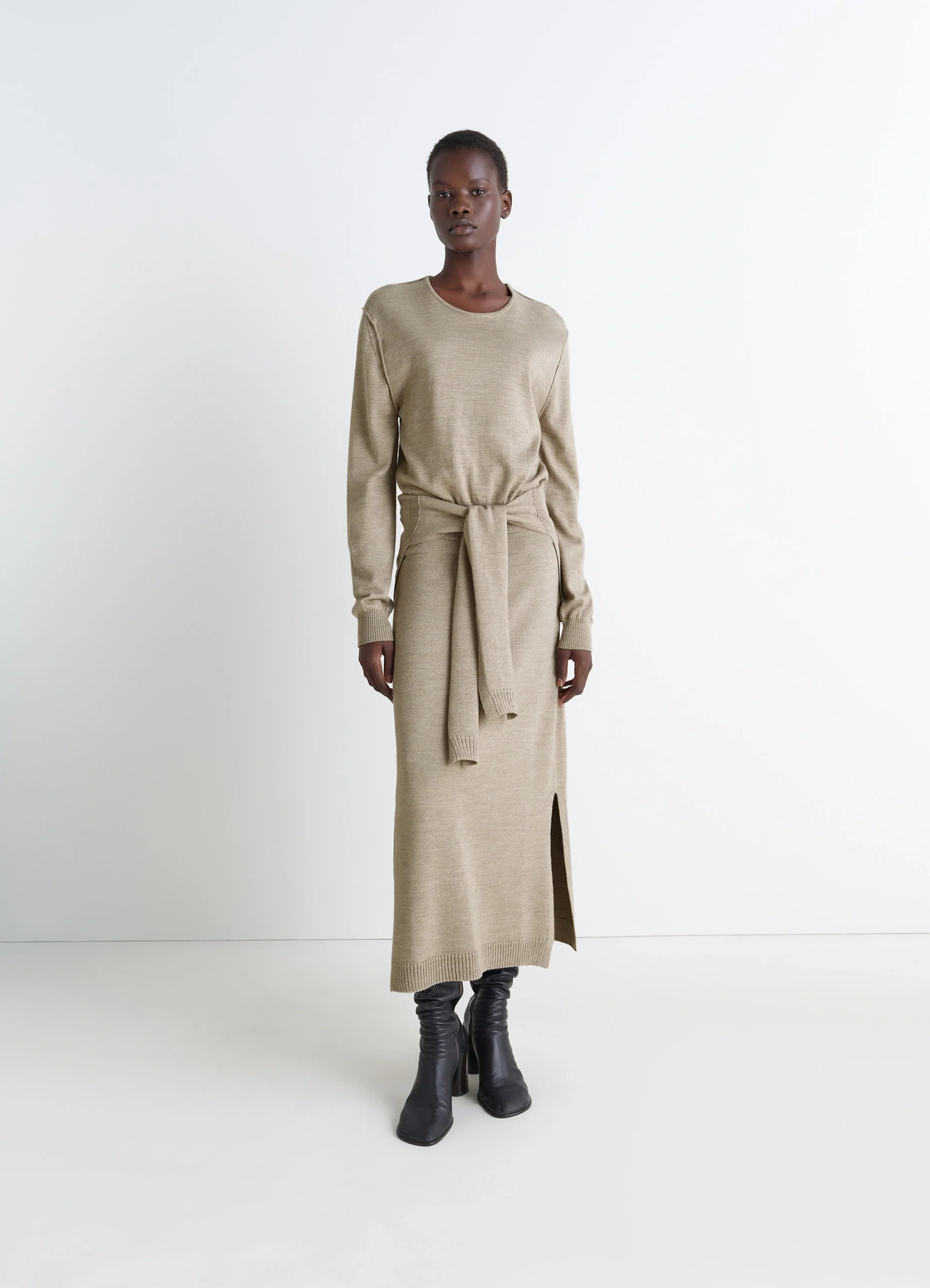 Lemaire trompe loeil crew neck jump in beige blended merino wool, model shot, full body side view side slit and belt tie