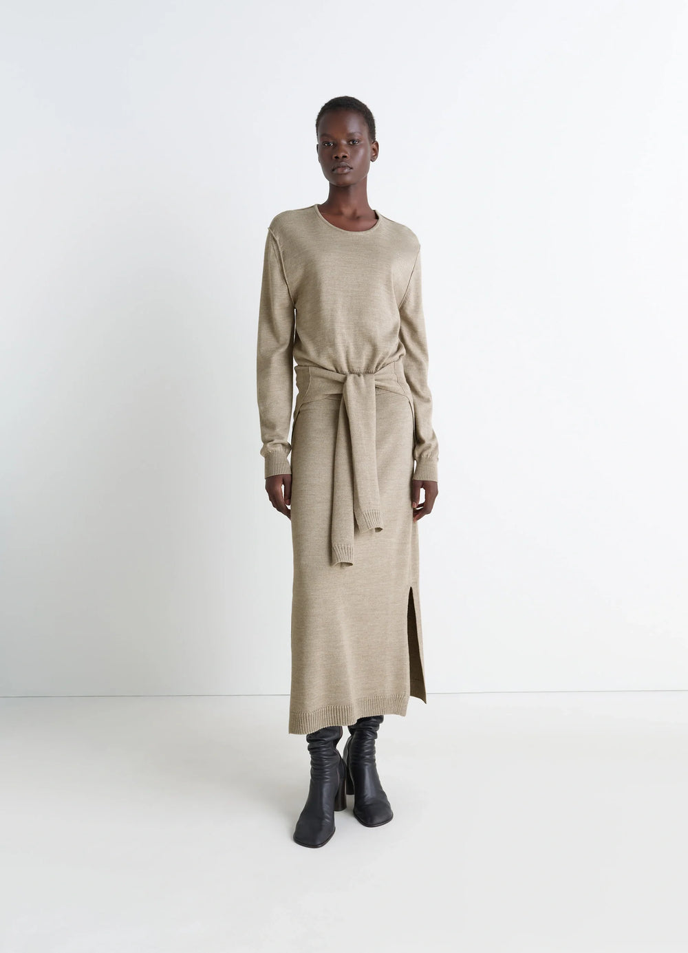 Lemaire Trompe LOeil Crew Neck Jump in Beige Blended Merino Wool, model shot, full body side view side slit and belt tie