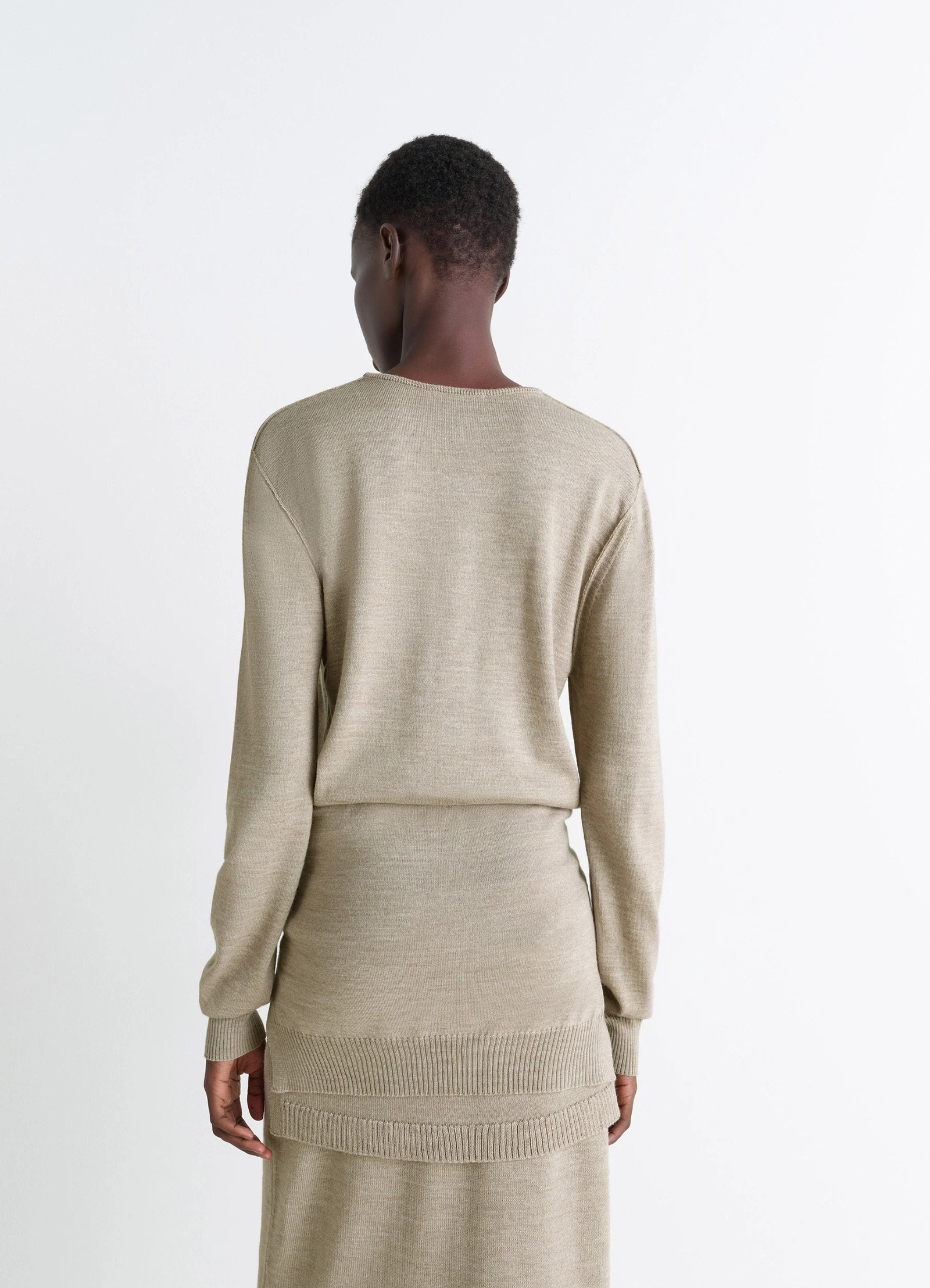 Lemaire trompe loeil crew neck jump in beige blended merino wool, model shot, back view ribbed hem detail