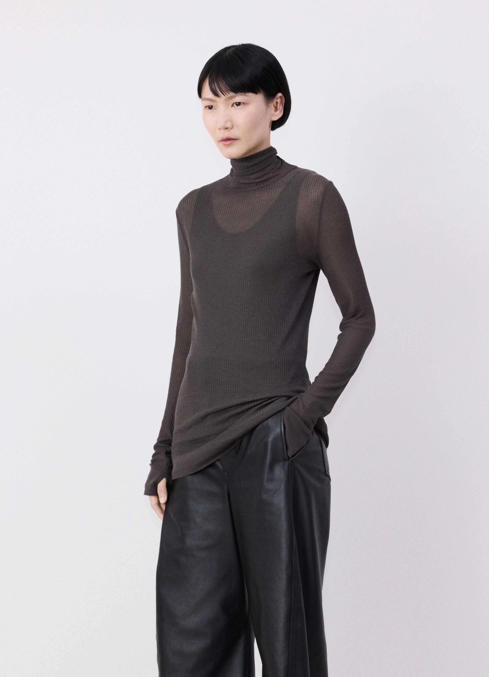 Emo seamless high neck top in dark brown viscose silk, model shot, front three-quarter view finely ribbed see-through