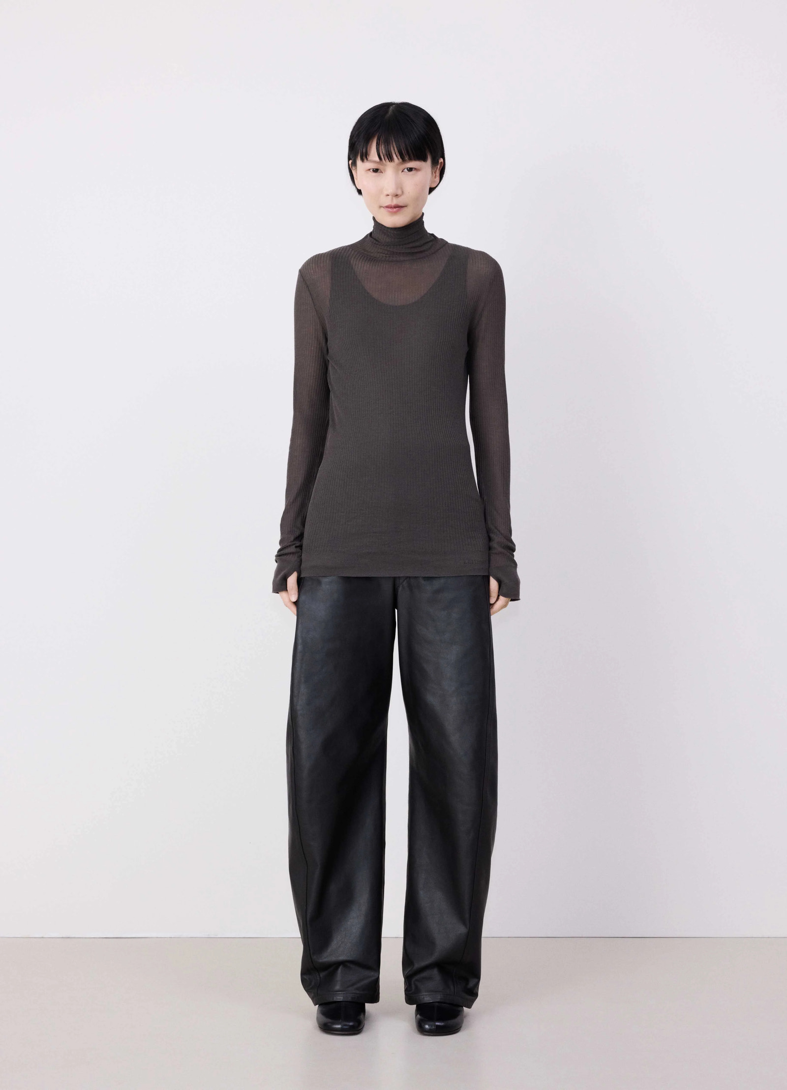 Emo seamless high neck top in dark brown viscose silk, model shot, front full-body view long sleeves, layered look