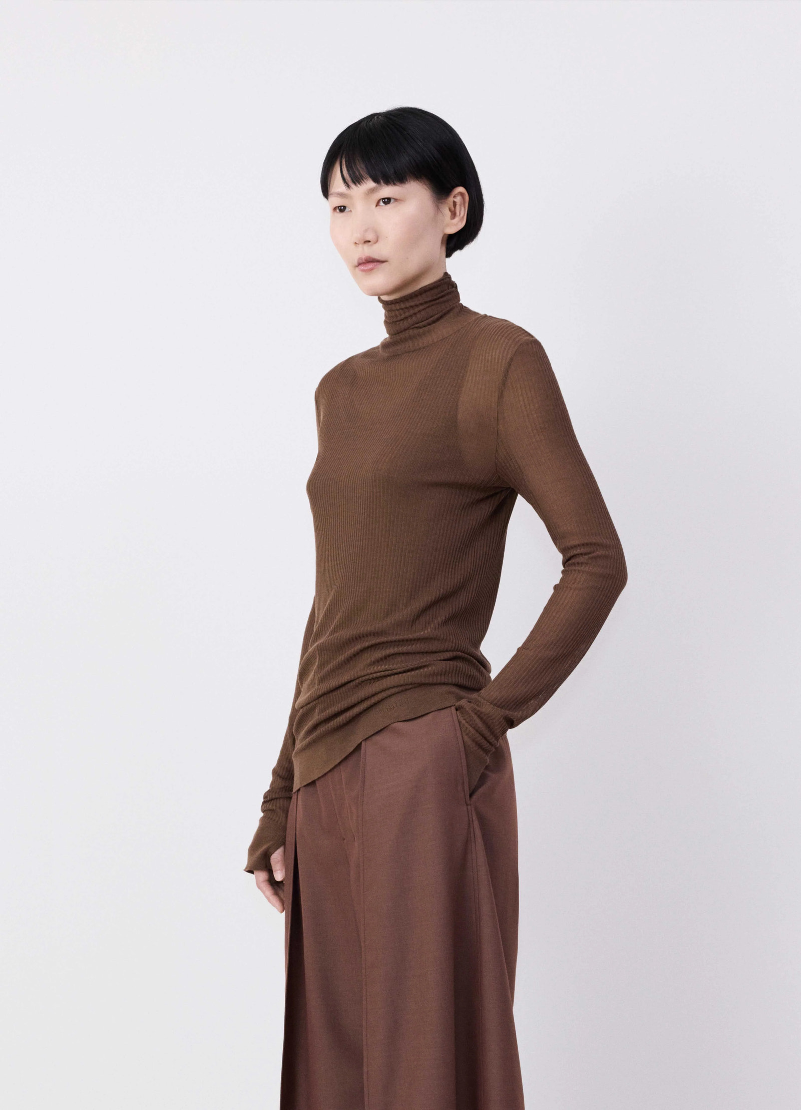 Emo seamless high neck top in viscose silk brown, model shot, side view ribbed, thumbhole cuffs