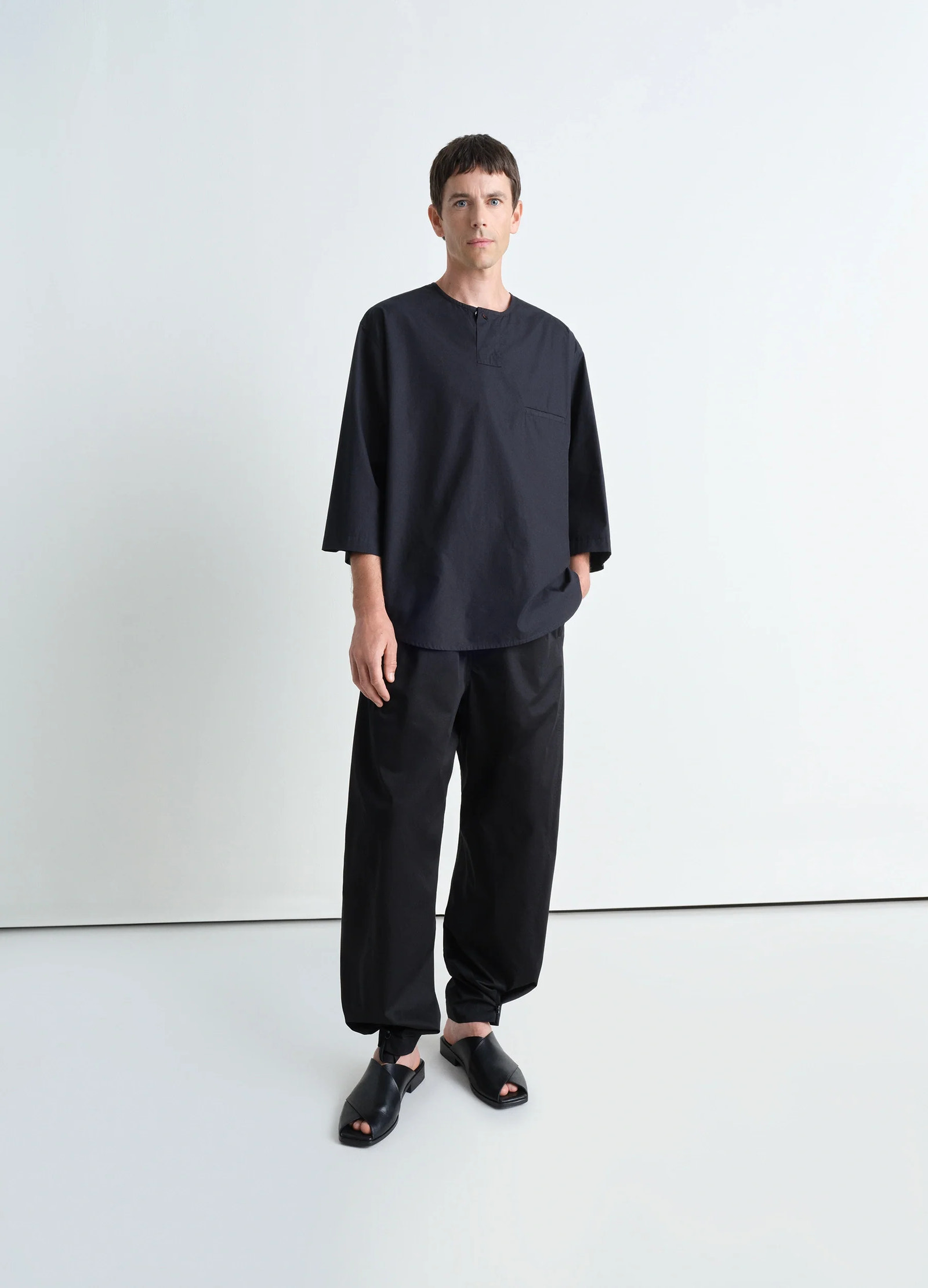 Short sleeve henley top in black heavy cotton poplin, model shot, 3/4 view slightly dropped shoulders