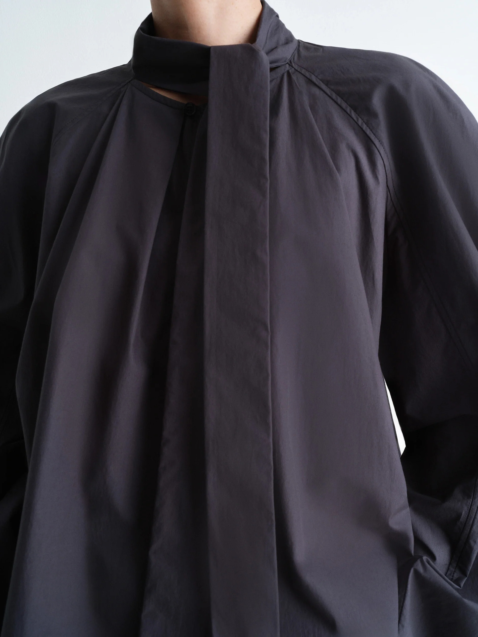Lemaire ascot blouse in lightweight washed cotton poplin, model shot, upper body close-up ascot tie detail