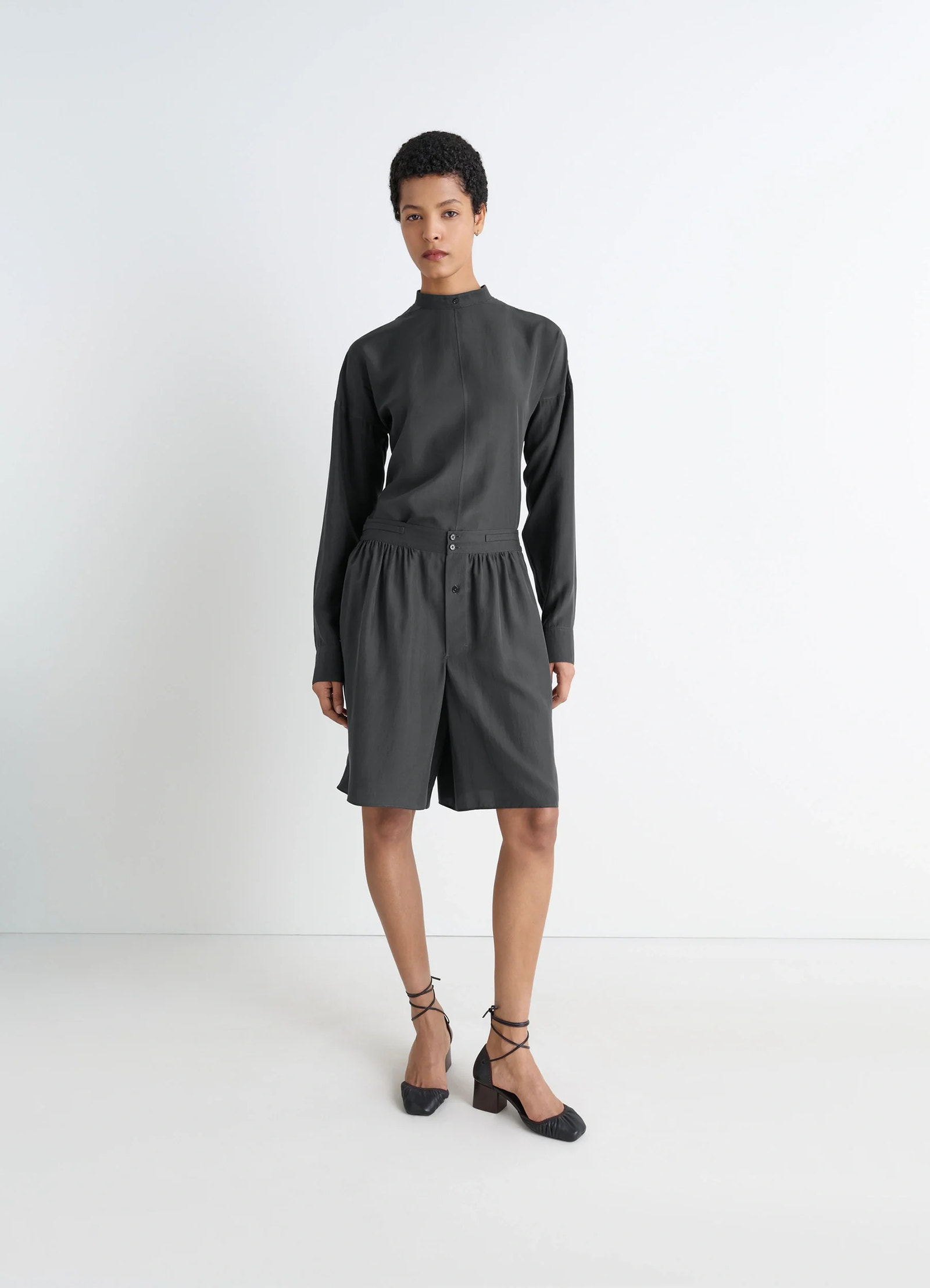 Light plastron top in black silk pongee, model shot, three-quarter view high neck, cuffed sleeves
