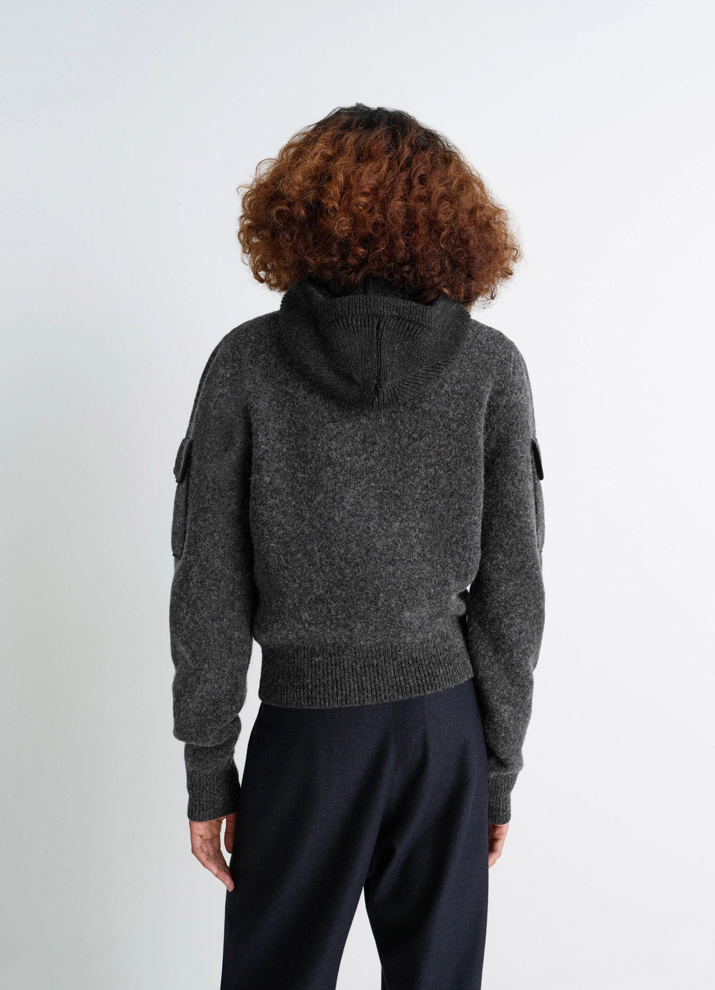 SWEATER WITH POCKETS in Shetland wool grey, model shot, back view hooded design