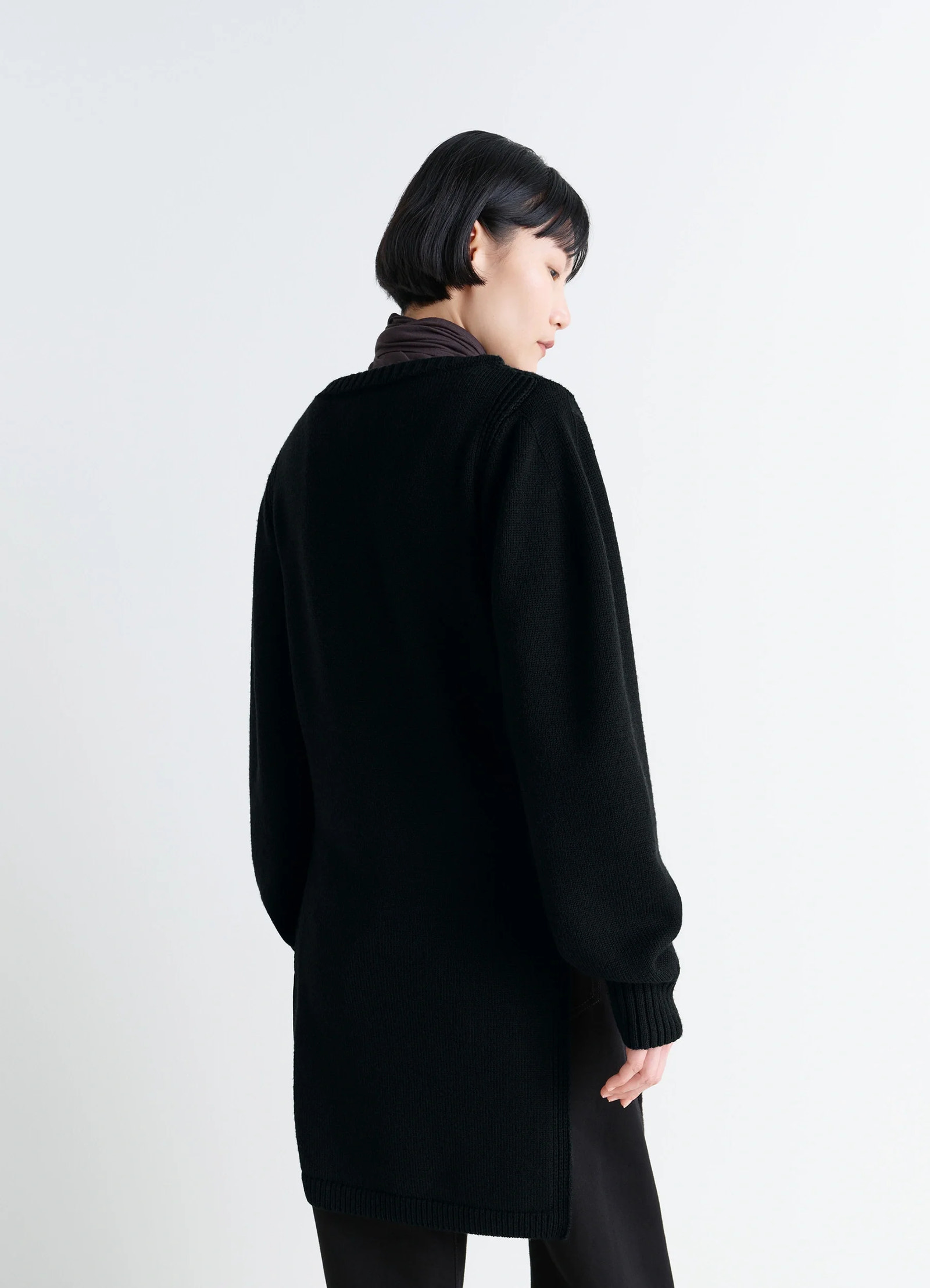 Sweater with slits in combed wool black, model shot, back view loose fit silhouette
