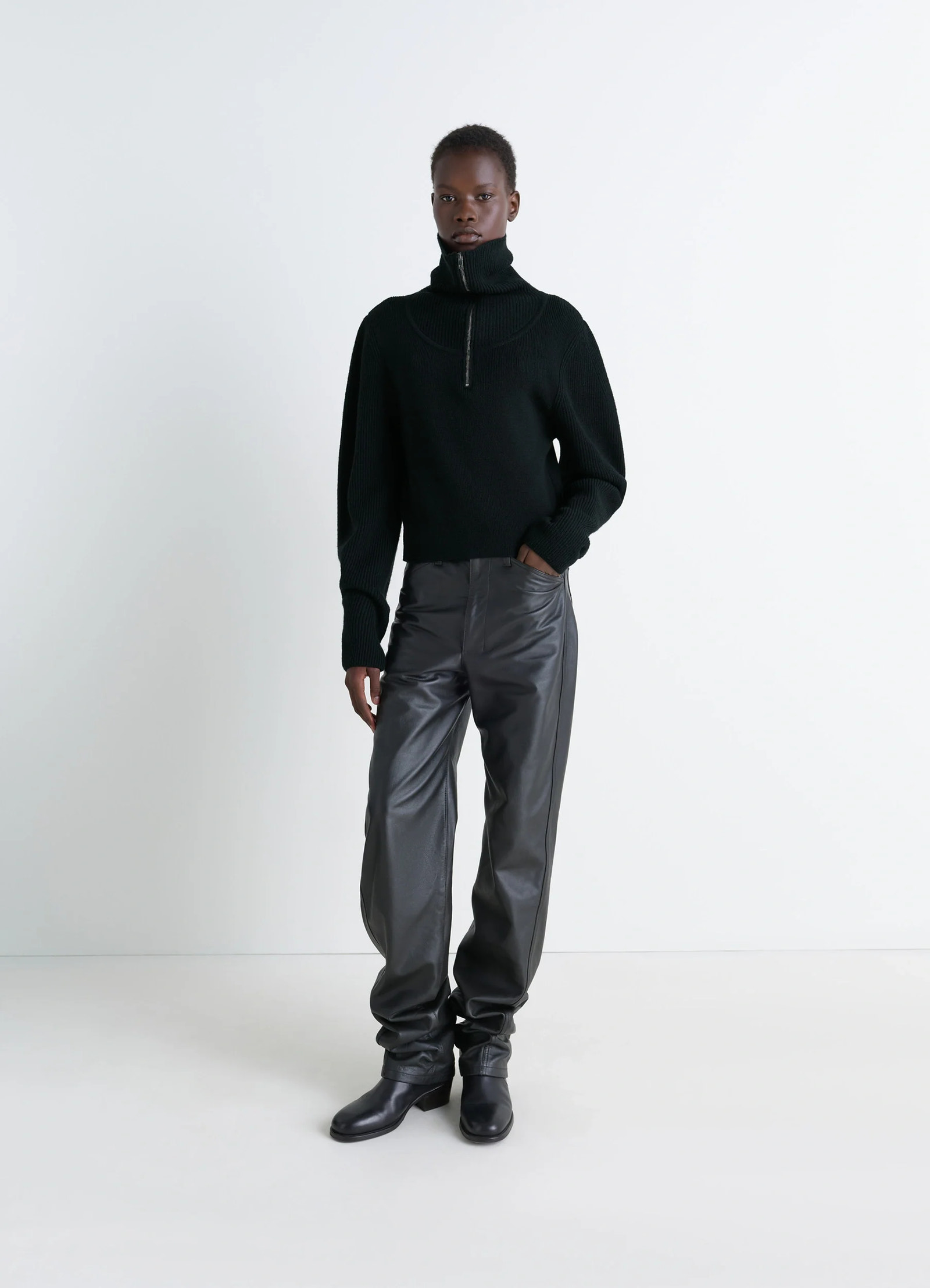 Zipped sweater in black combed wool, model shot, three-quarter view ribbed cuffs and collar