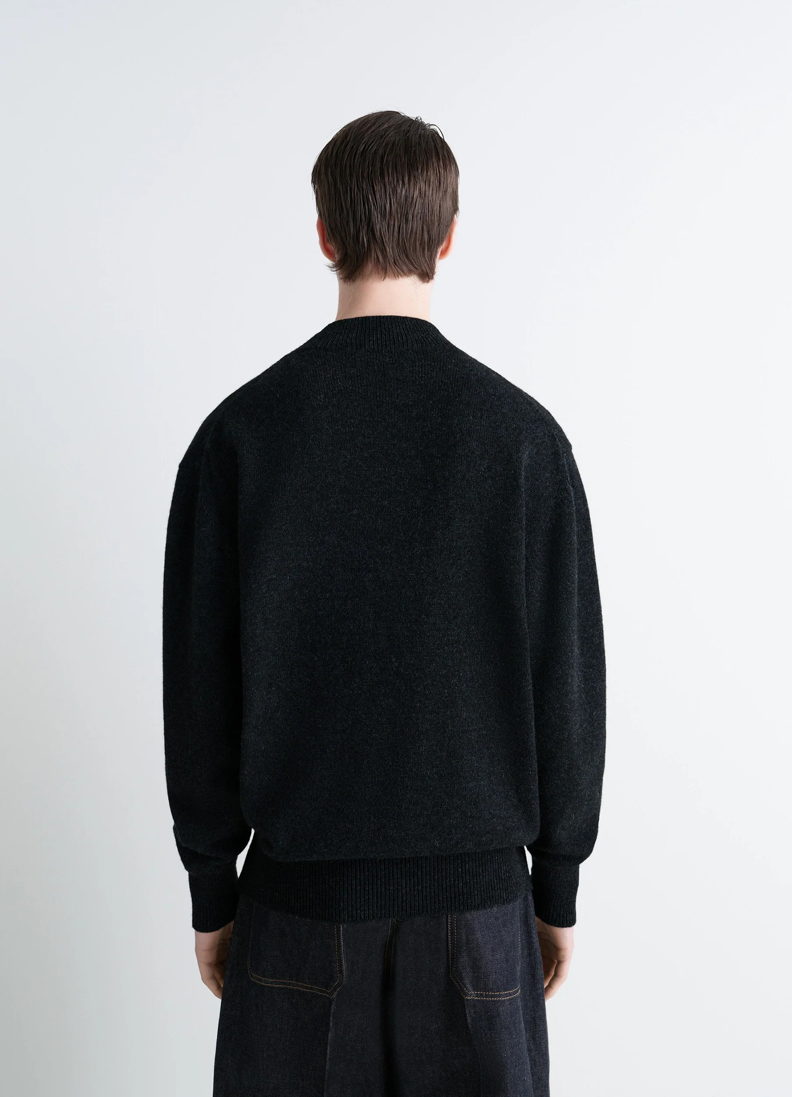 Mock neck sweater in black alpaca yak wool, model shot, back view straight hem over jeans