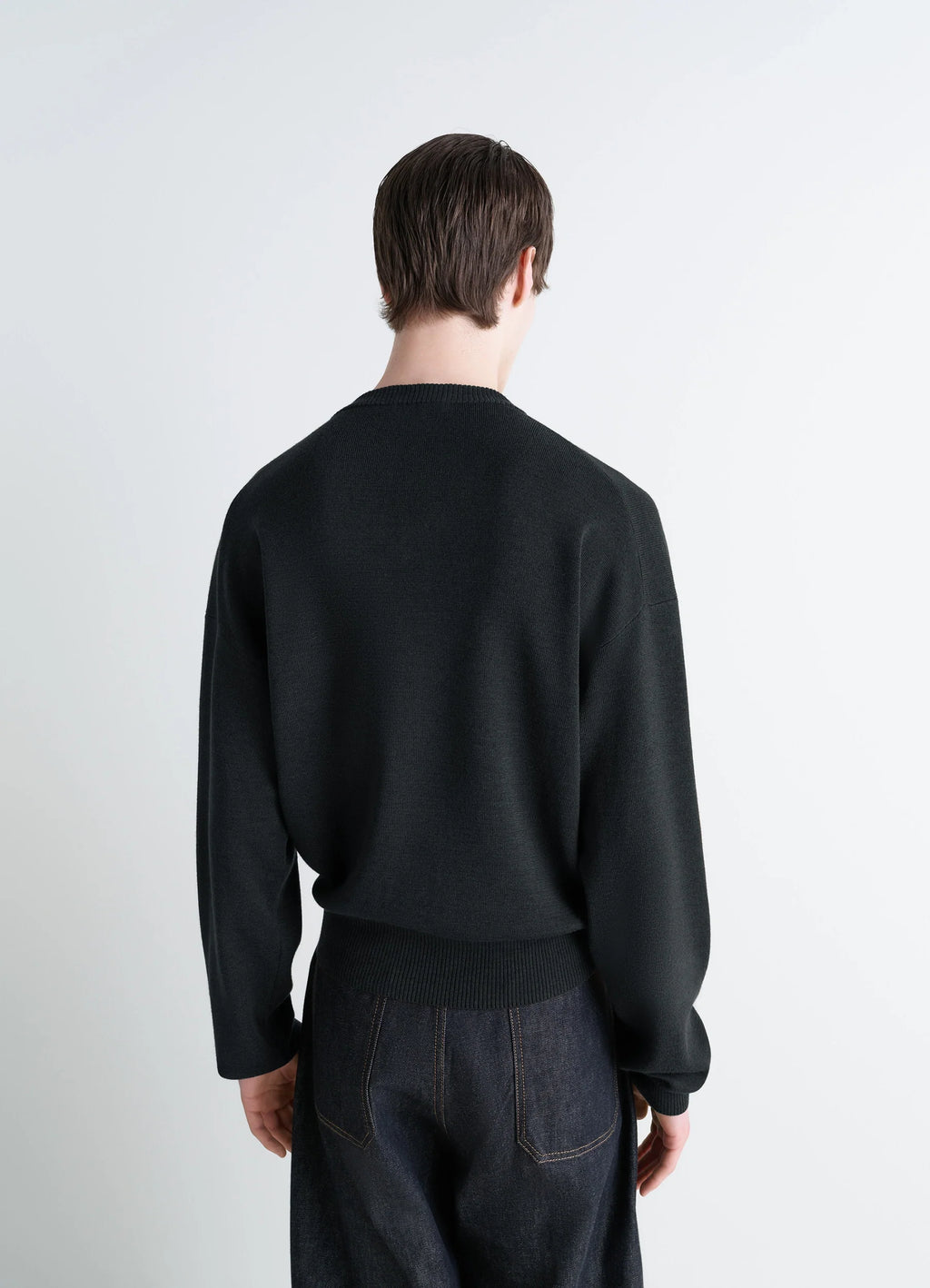 Lemaire V Neck Sweater in Blended Merino Wool in Black, model shot, back view ribbed cuffs