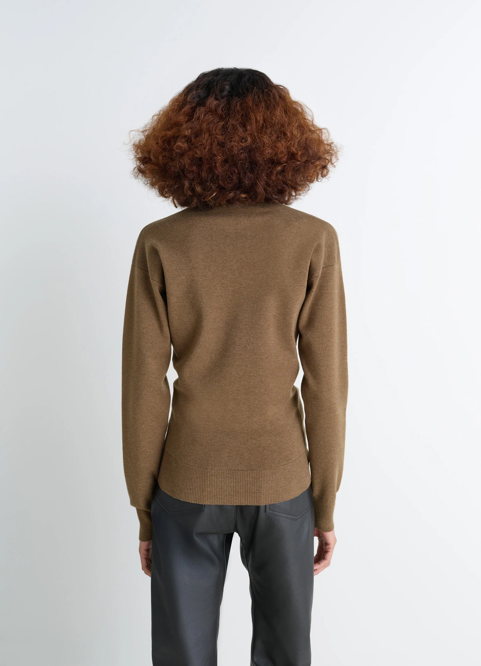 Lemaire buttoned fitted cardigan in mercerized wool, model shot, over-shoulder view ribbed hem detail