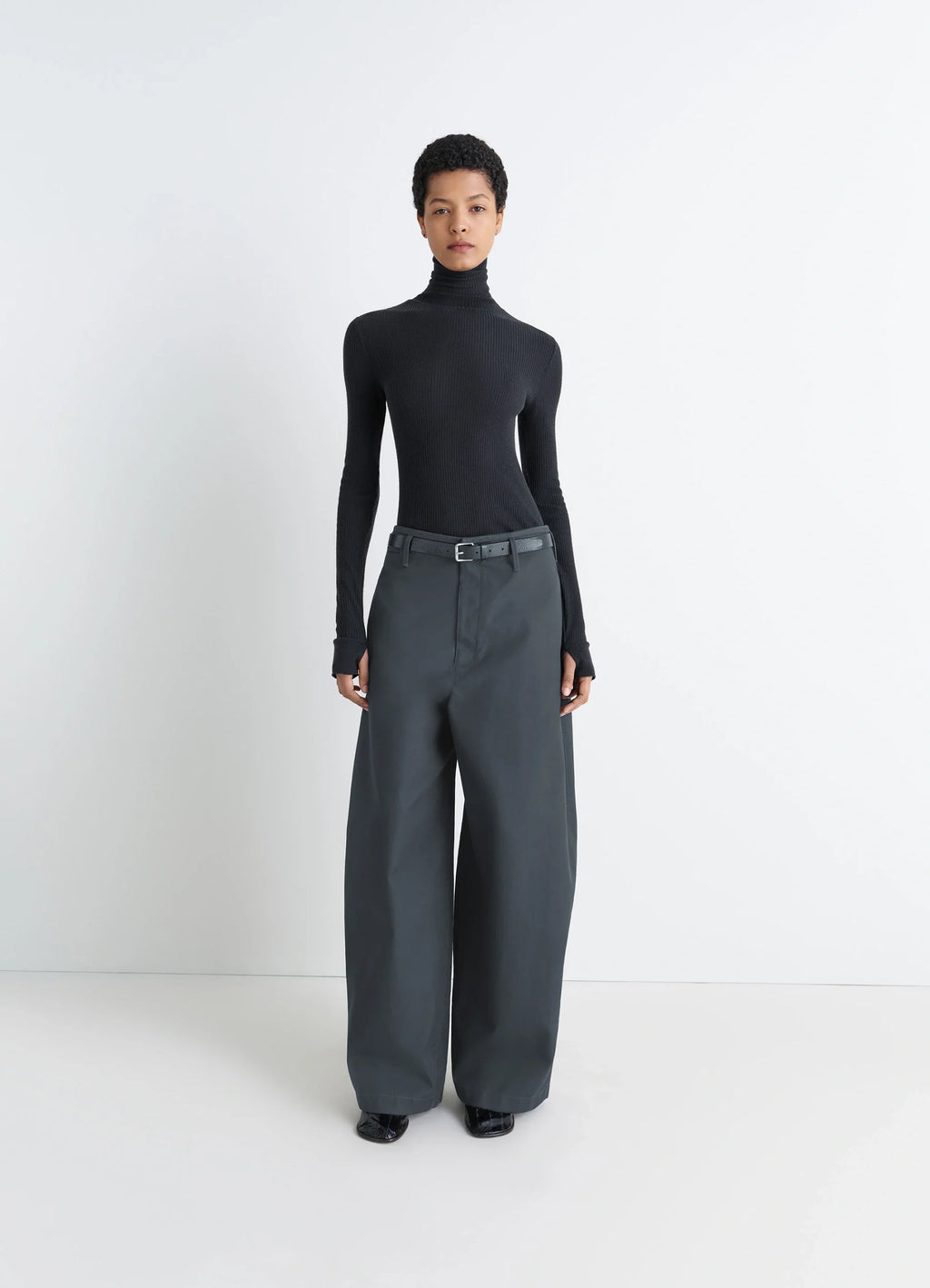 Lemaire Seamless High Neck Top in Black Finely Ribbed Merino Wool, model shot, side profile long sleeve high neck