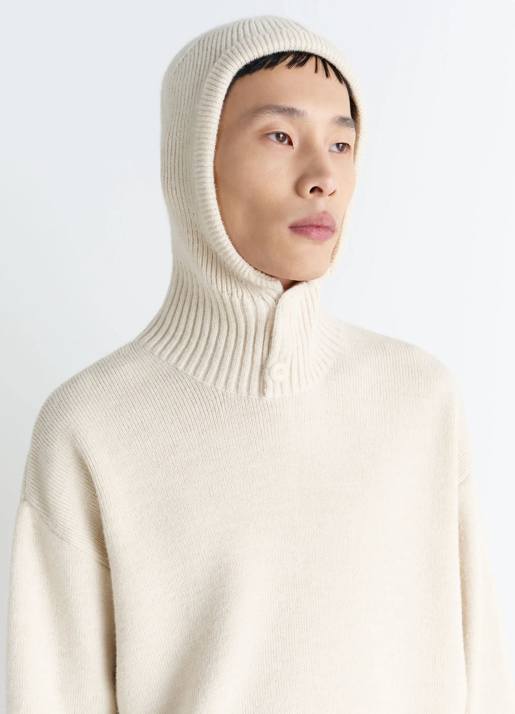 Lemaire Hooded Sweater in Cream Wool Alpaca, model shot, three-quarter close-up ribbed hood with button detail
