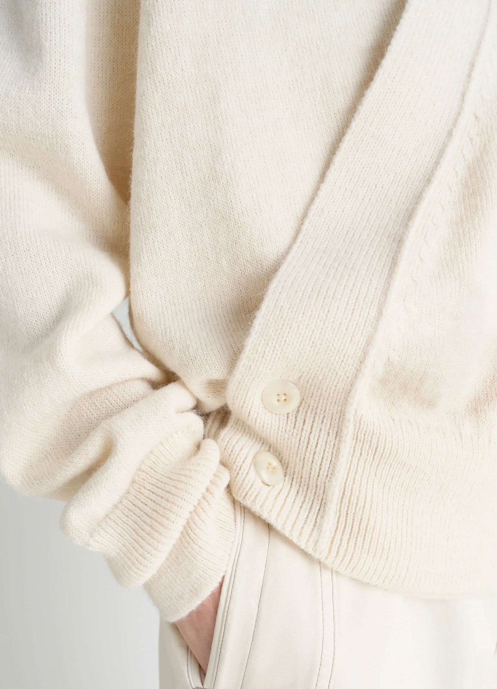Lemaire wrap cardigan in ivory wool alpaca, model shot, close-up sleeve detail ribbed cuff buttons visible