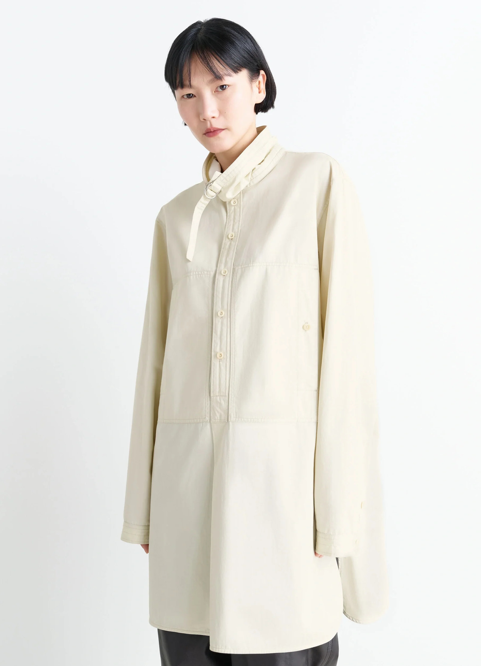 Lemaire chest pocket long liquette in lightweight satin cotton, model shot, three-quarter view loose fit with metal ring