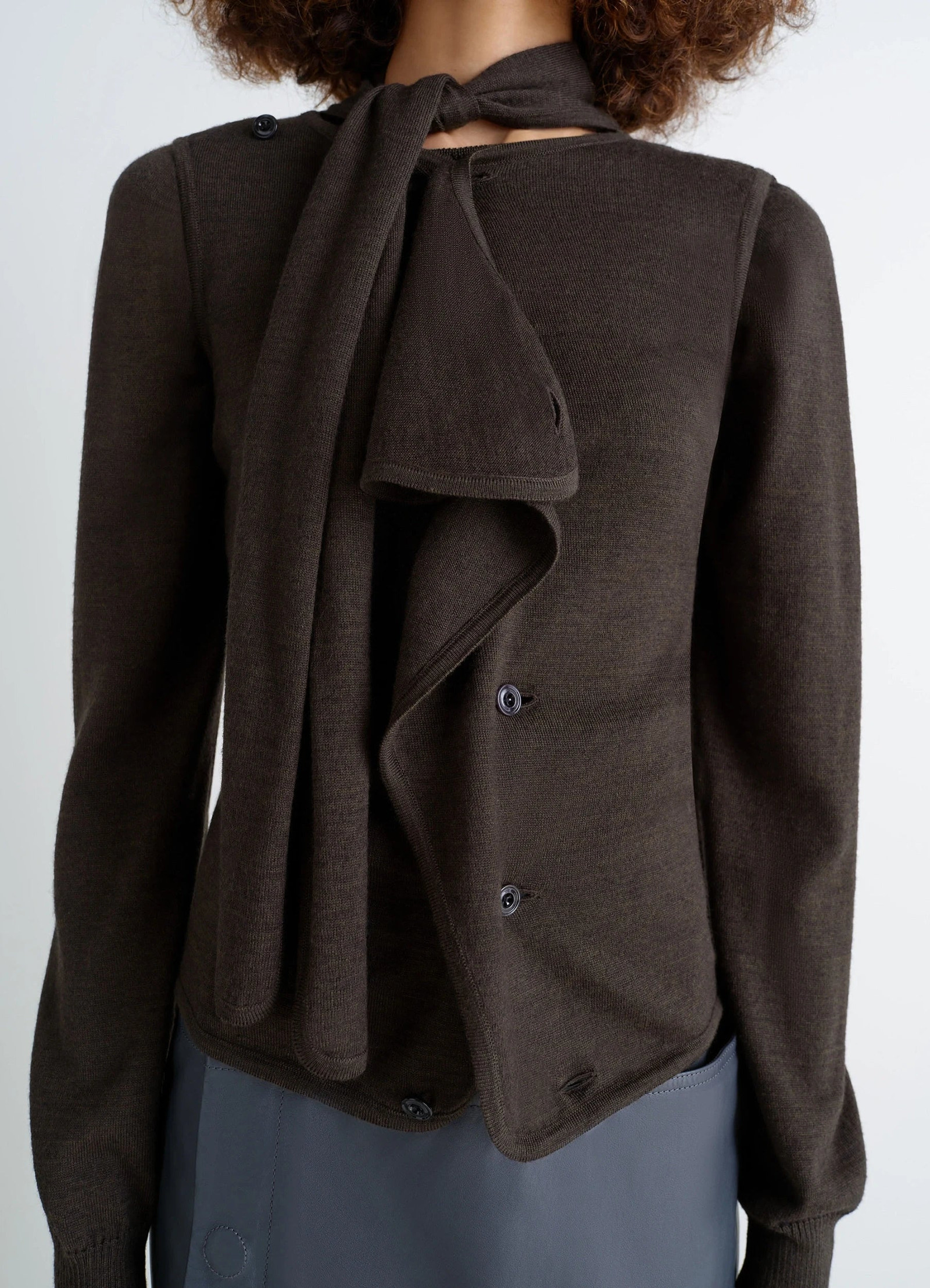 Lemaire asymmetrical sleeveless car in blended merino wool, model shot, detail shot scarf tie-neck detail