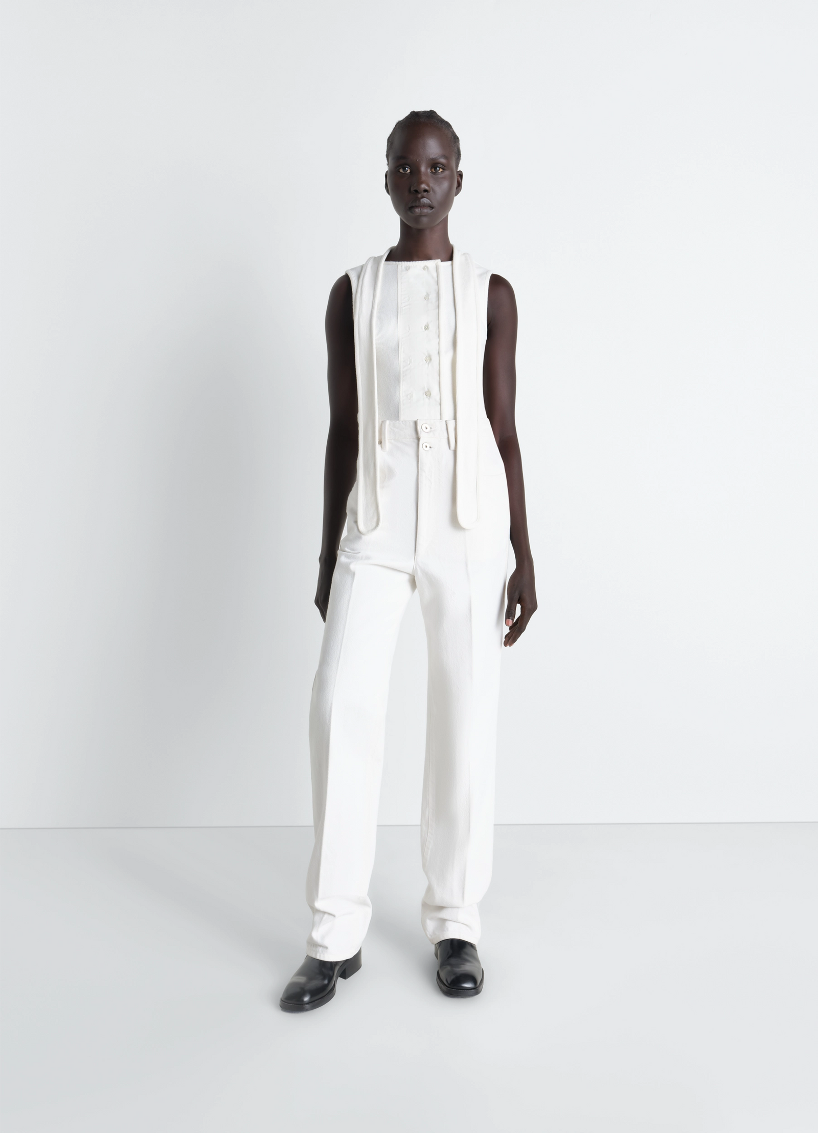 Asymmetrical fitted top in white cotton lined rib jersey, model shot, three-quarter view fitted cut with buttons