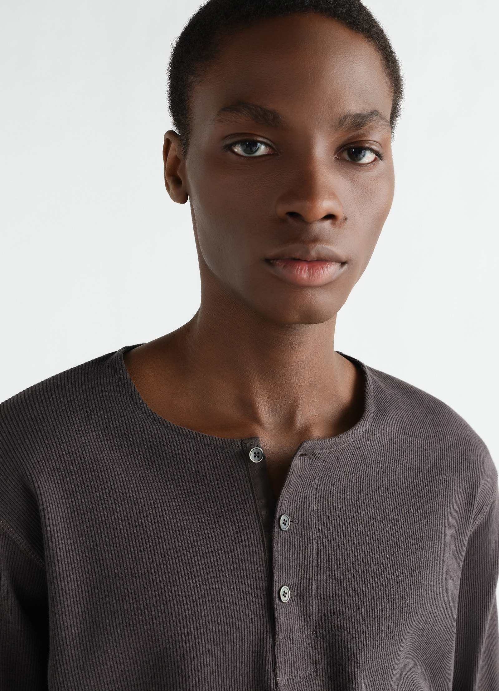 Long-sleeve dark grey linen-cotton ribbed jersey henley t-shirt by lemaire worn by a model close-up front