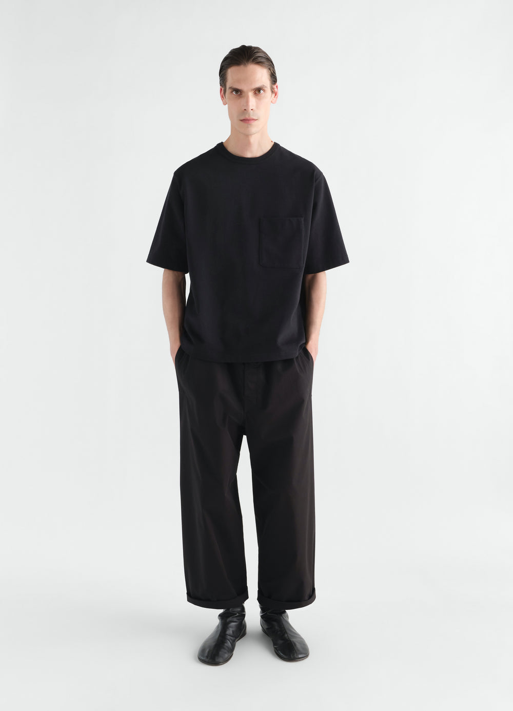T-shirt boxy en jersey de coton compact, coloris noir, porté par un mannequin, vue de face, poches visibles