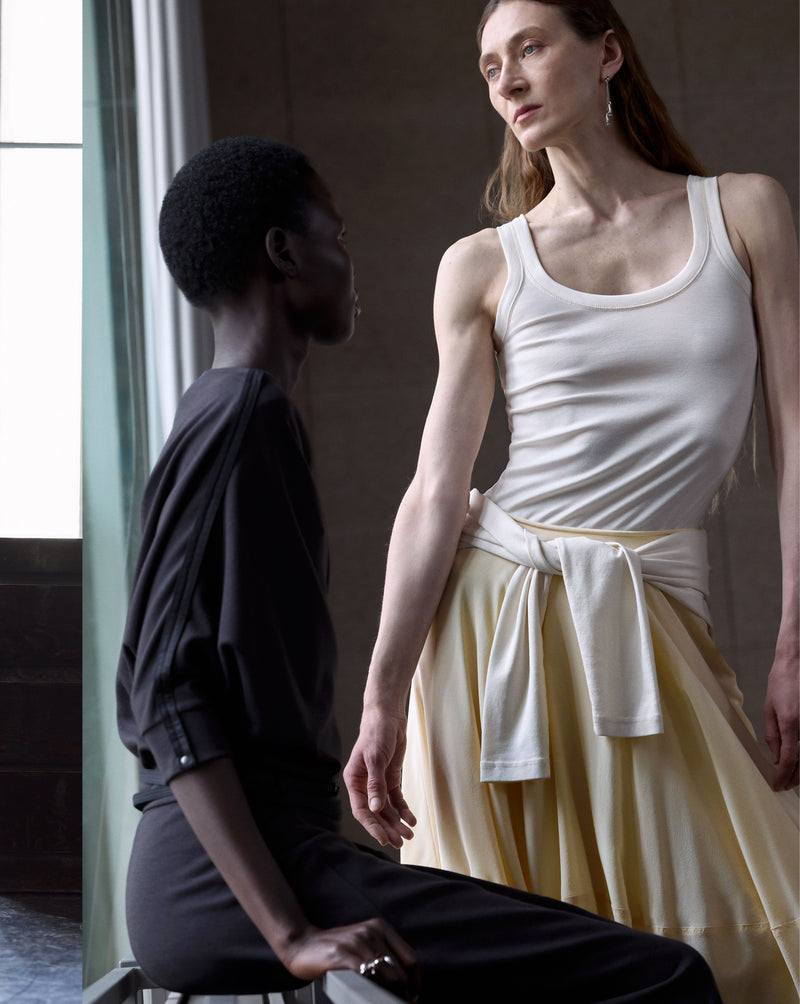 White tank top in white cotton, model shot, side view fitted design
