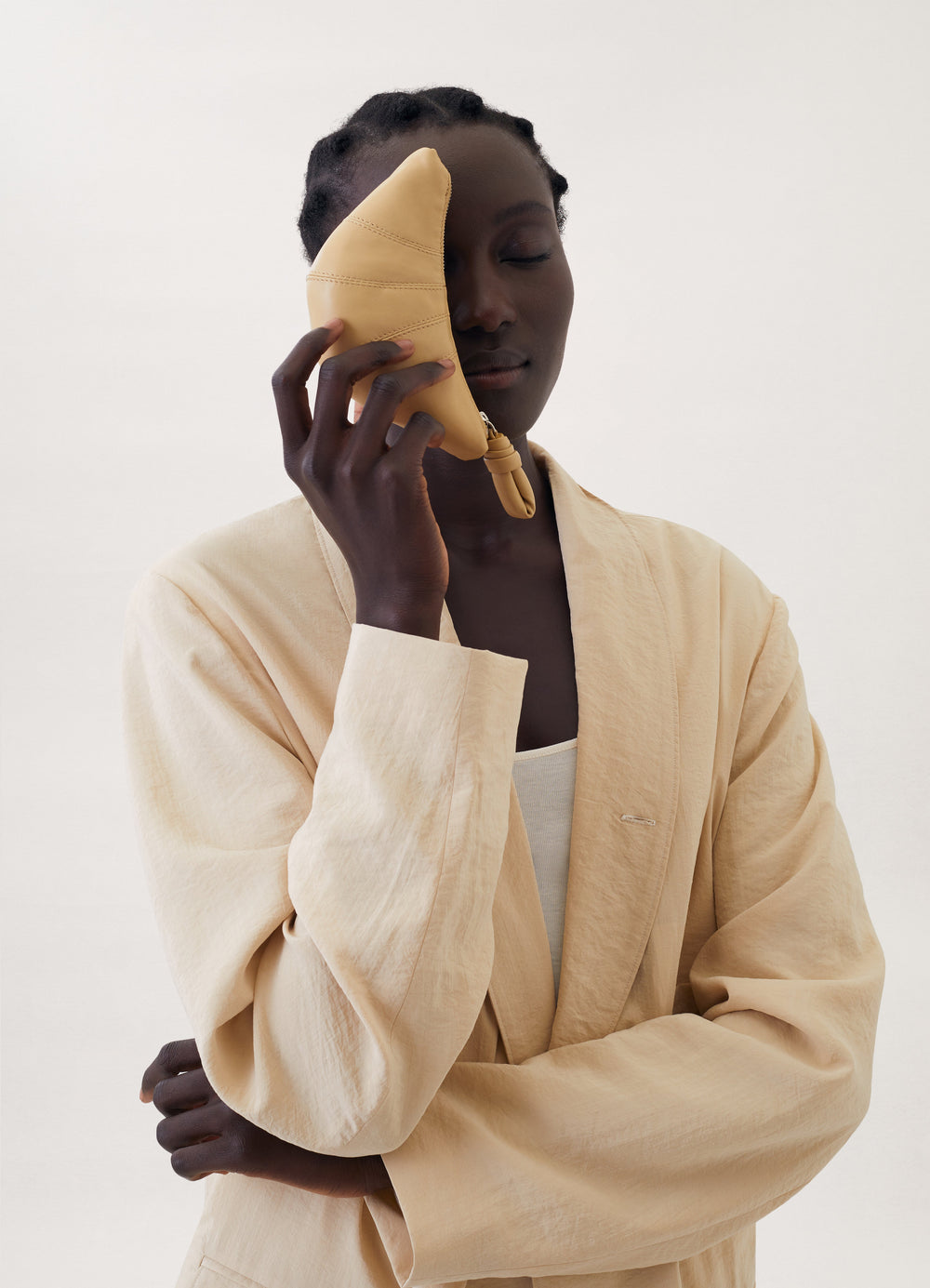 Croissant Coin Purse in Coated Linen Canvas, model shot, posed face press view face side held, soft handheld