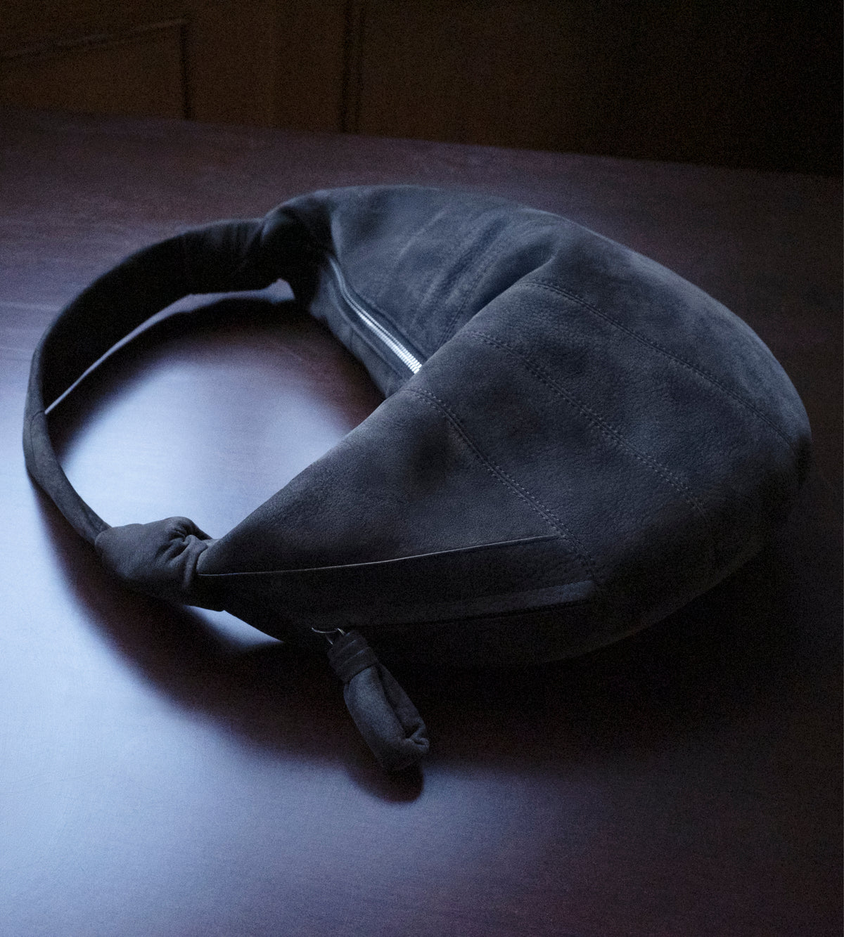 Mini Fortune croissant bag by LEMAIRE in dark grey alpaca nubuck leather with knotted handle front view on white background