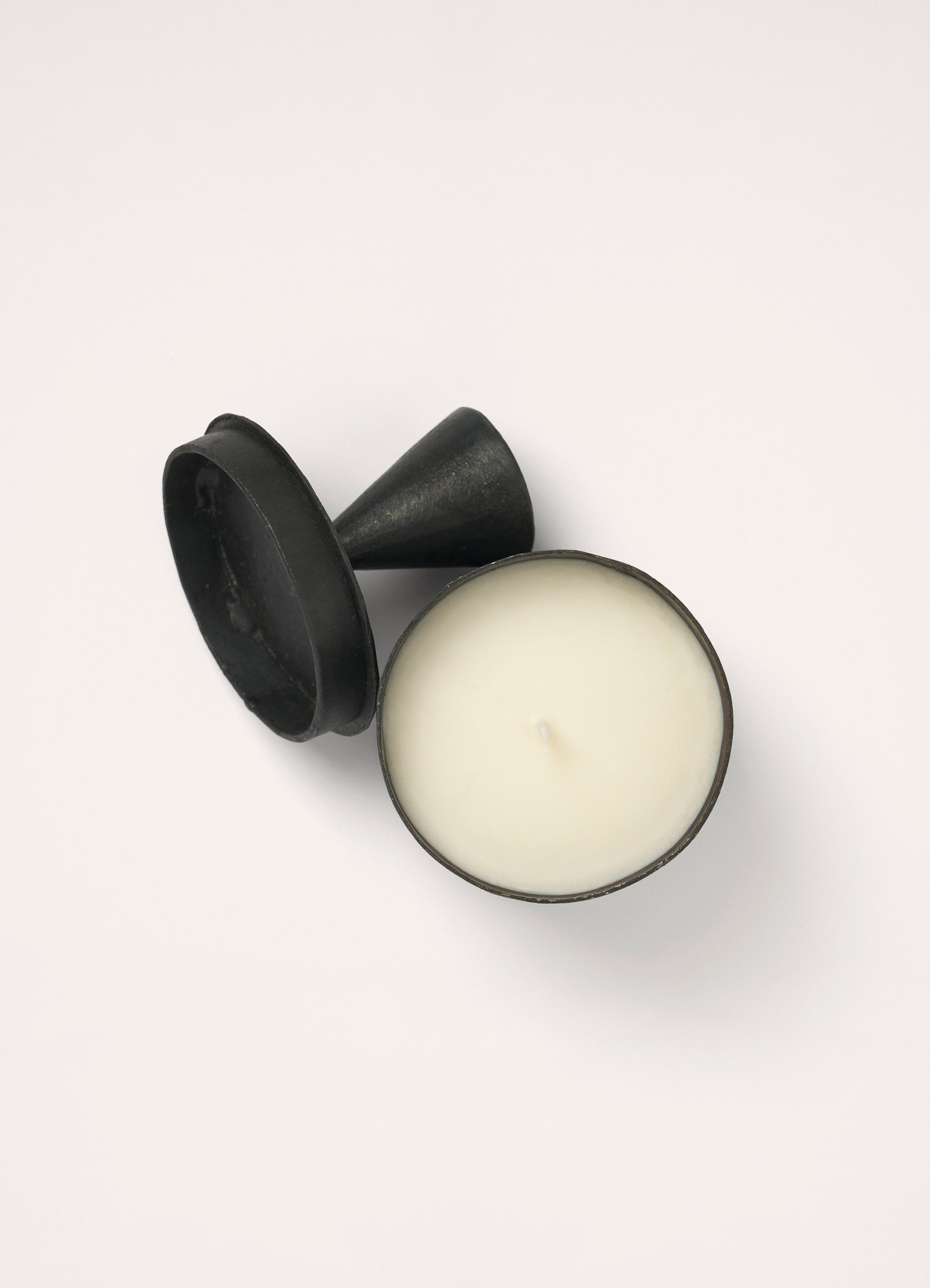 Bois d’orage candle in black hand-poured wax, product shot, top view lid off wax centered
