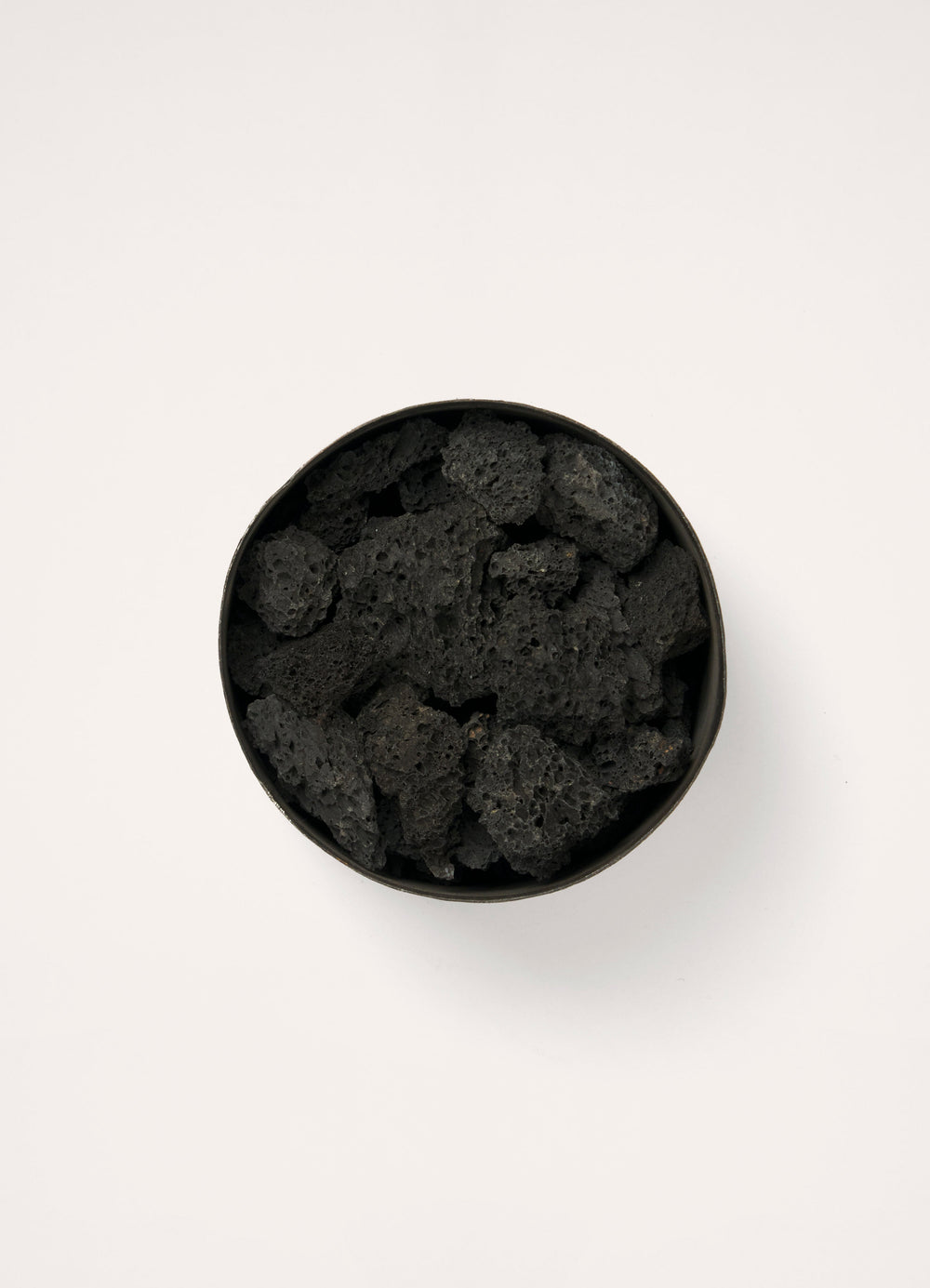 Mad et Len for Lemaire Bois d’Orage in Black Metal and Lava Stone, product shot, overhead view filled with lava stones