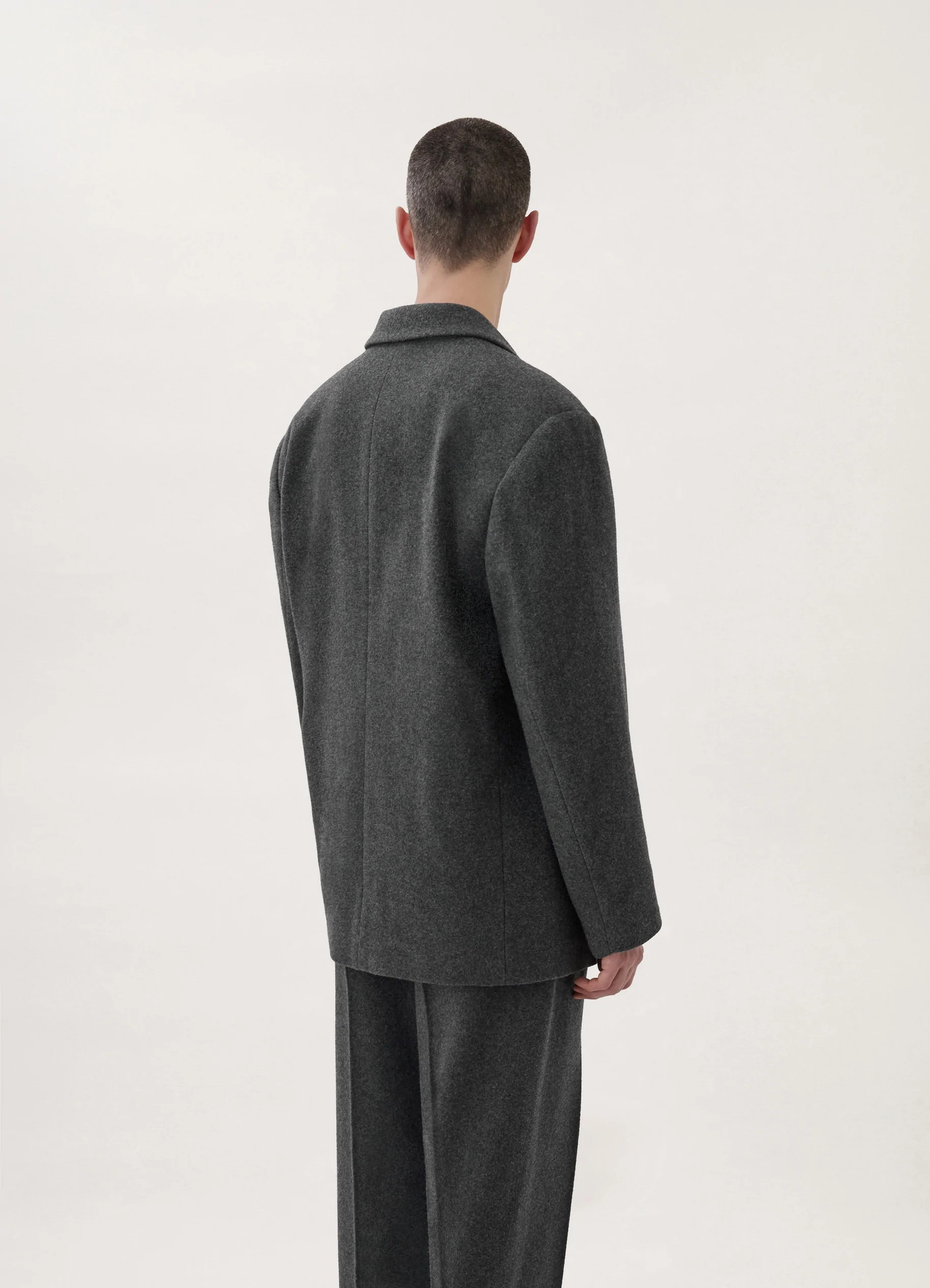 Lemaire boxy single-breasted jacket in felted wool, model shot, back three-quarter view clean seam back detail