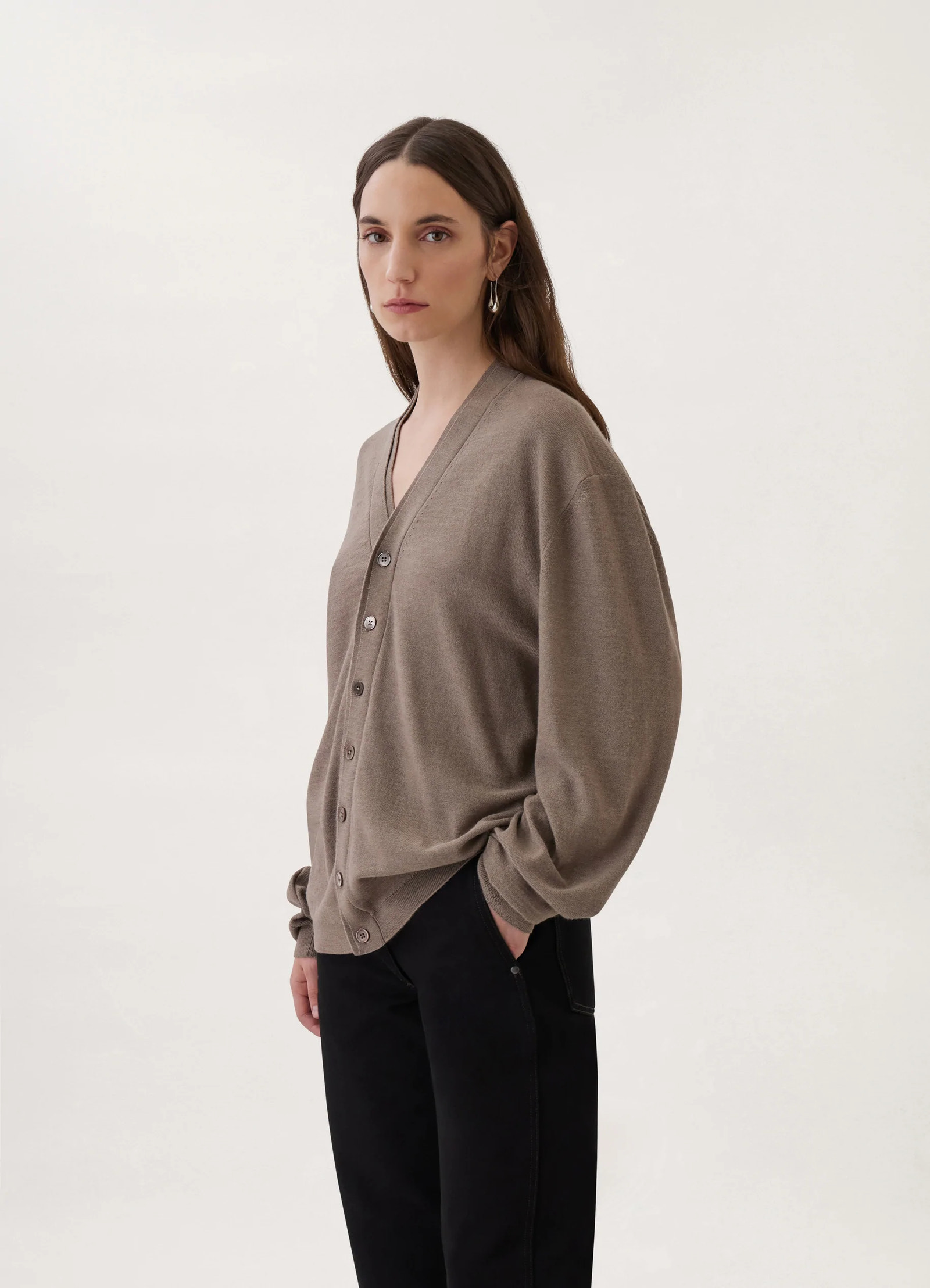 Loosely crafted cardigan in heather taupe knit, model shot, side profile view button-up v-neck design