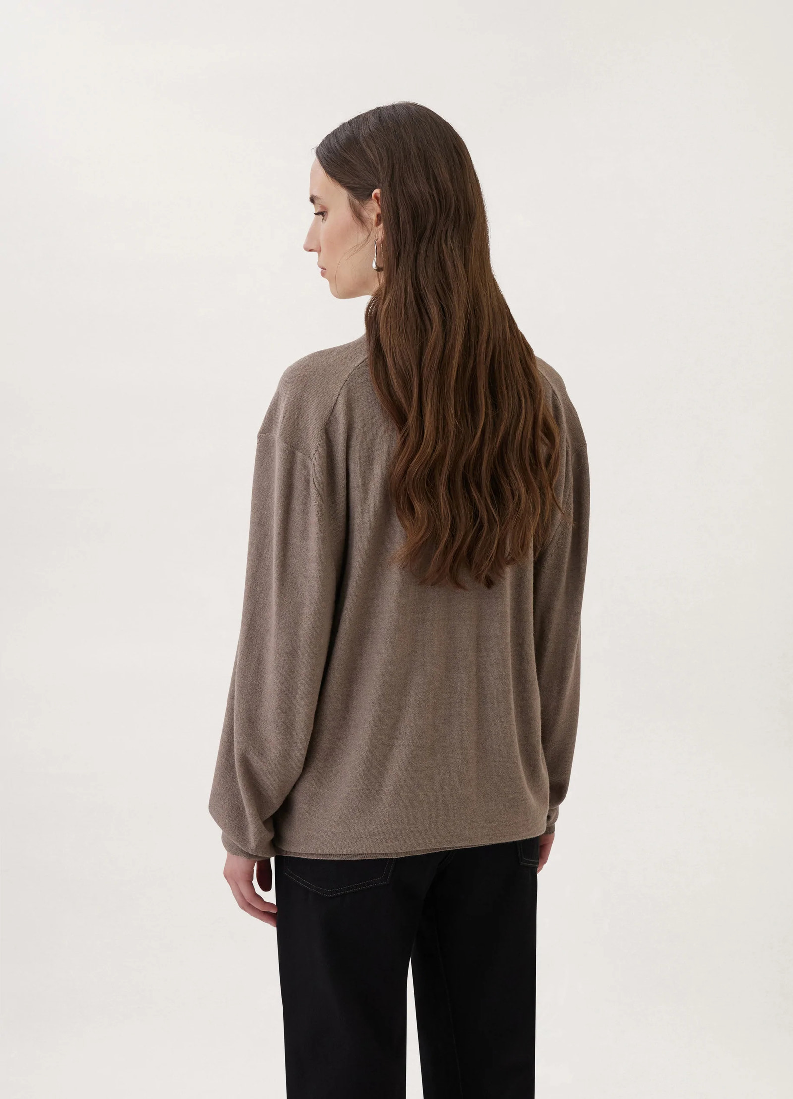 Loosely crafted cardigan in heather taupe knit, model shot, back view oversized sleeves