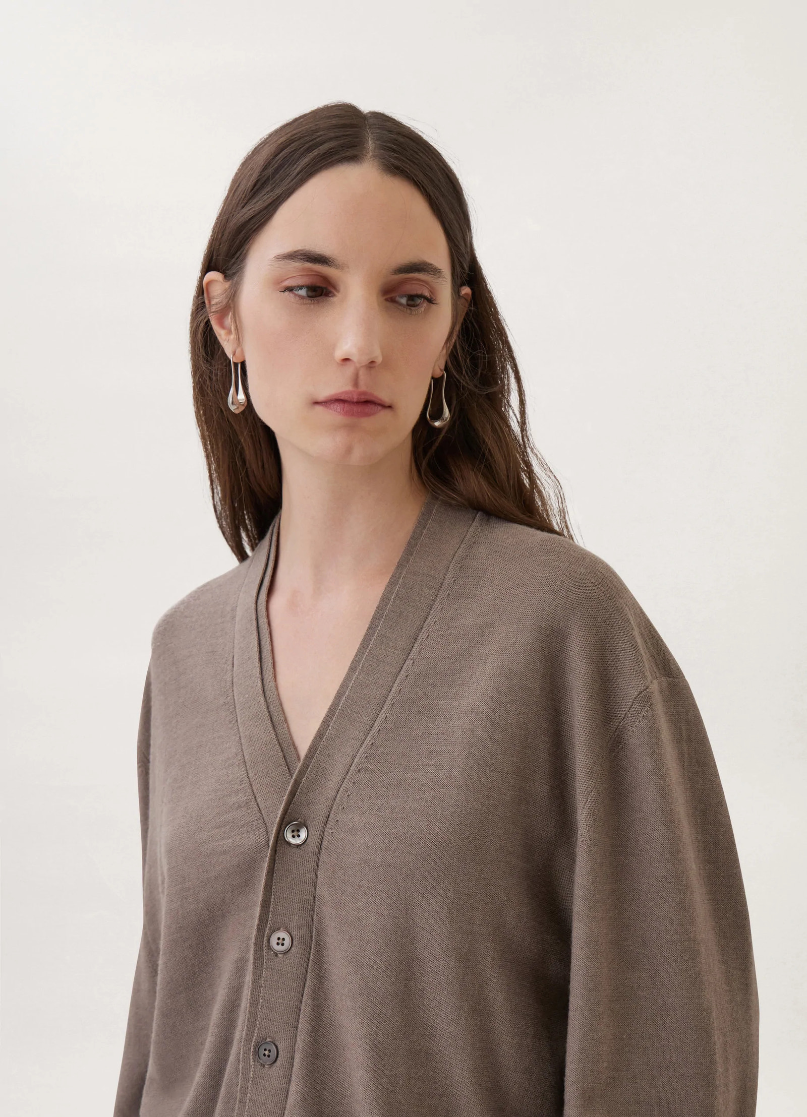 Loosely crafted cardigan in heather taupe knit, model shot, close-up angle v-neck button details