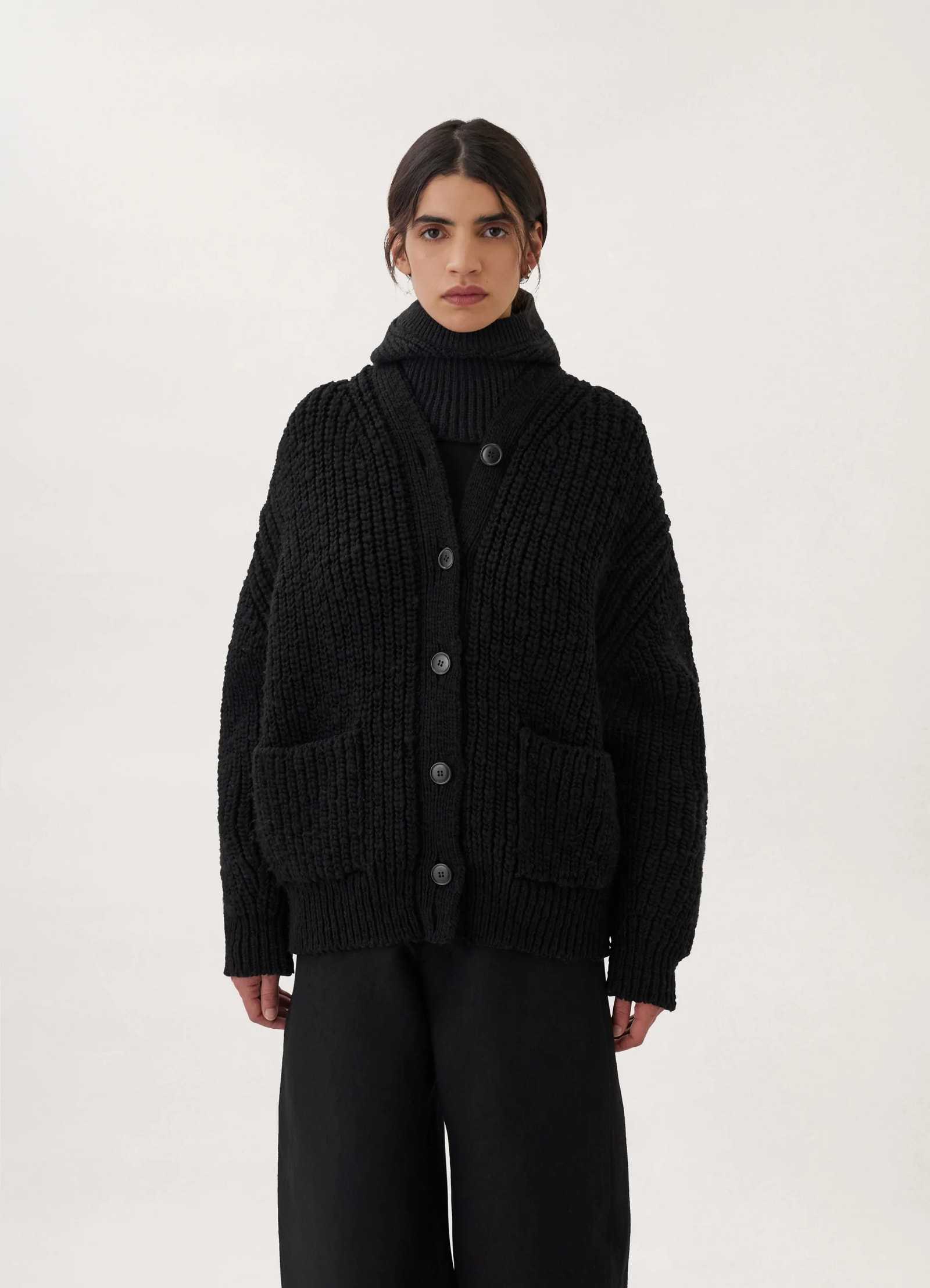 Chunky cardigan in black thick wool, model shot, close-up view buttoned fit with turtleneck