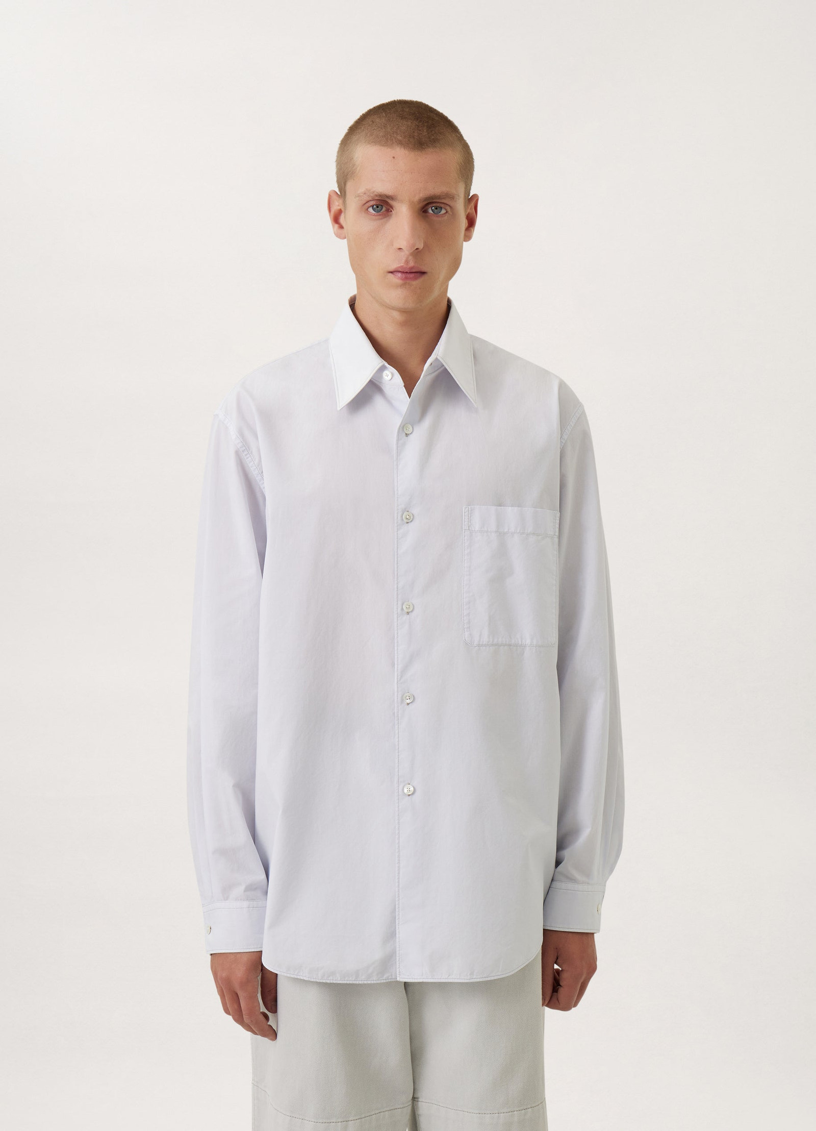 Lemaire regular long sleeve shirt in white compact cotton, model shot, three-quarter view chest pocket visible