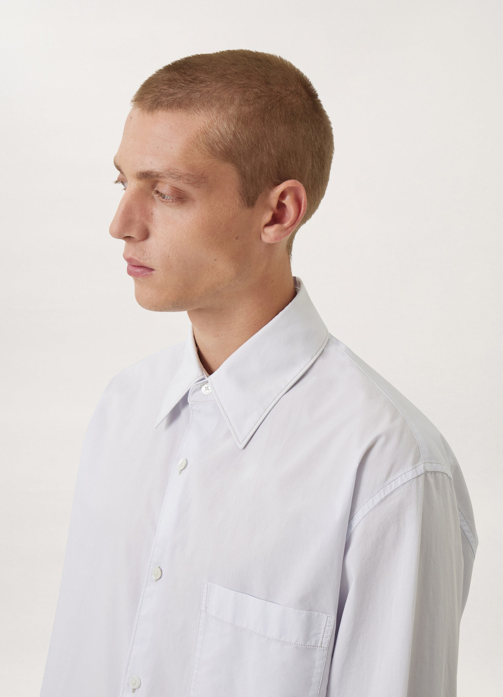 Lemaire regular long sleeve shirt in white compact cotton, model shot, side profile view convertible collar detail