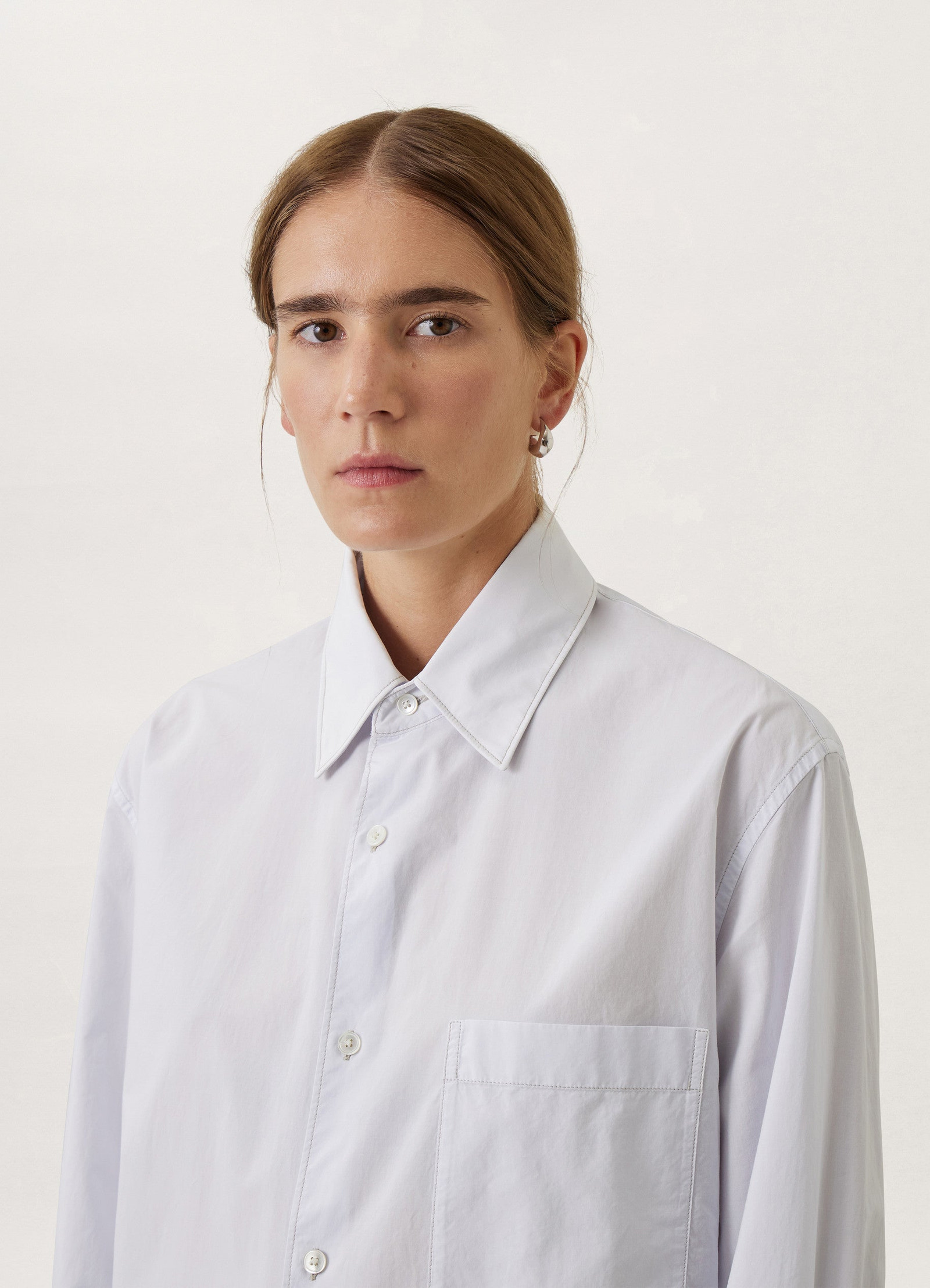 Lemaire regular long sleeve shirt in white compact cotton, model shot, close-up shoulder view sharp collar detail