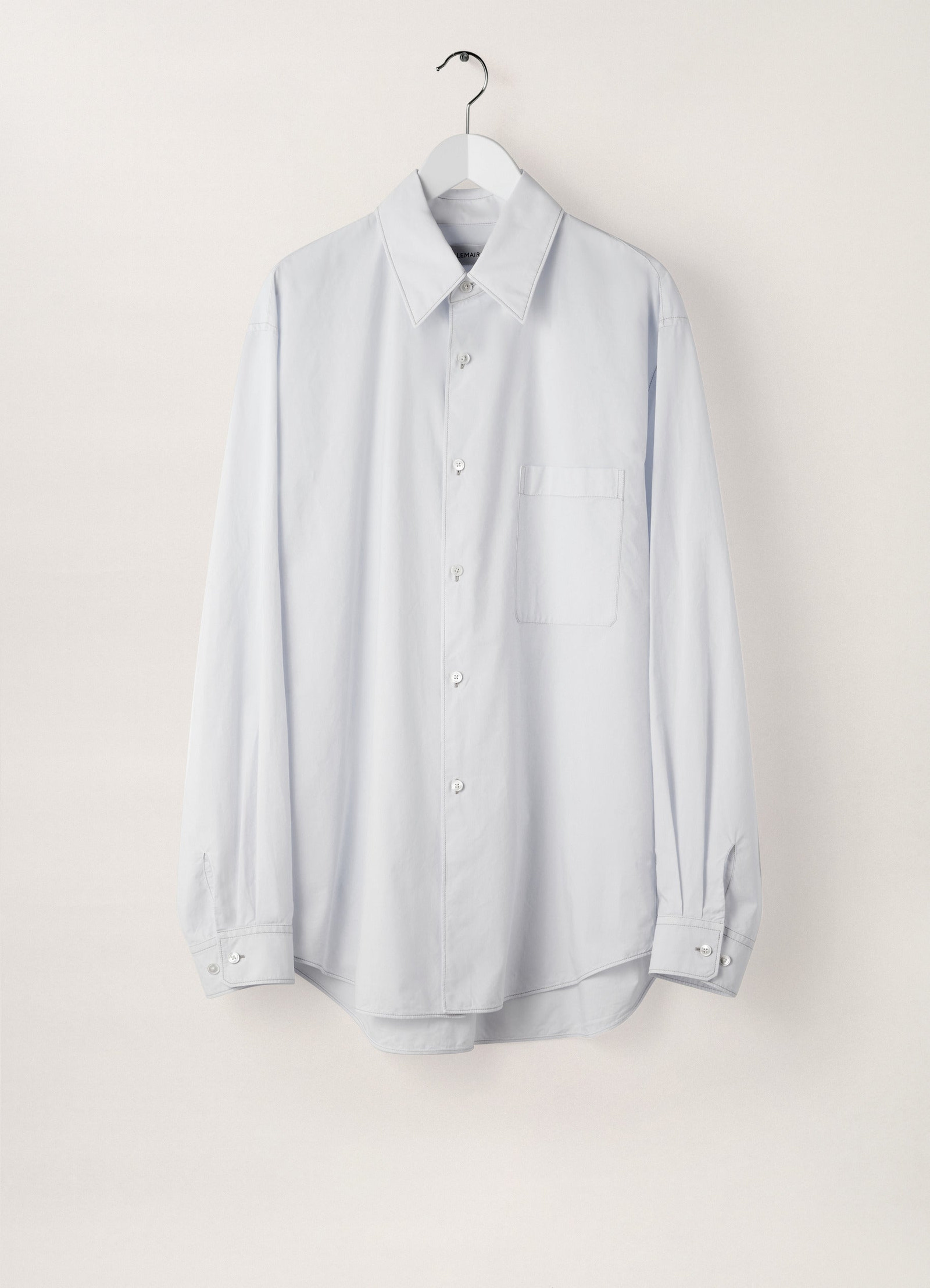 Lemaire regular long sleeve shirt in white compact cotton, product shot, hanger front focus view buttoned cuffs visible