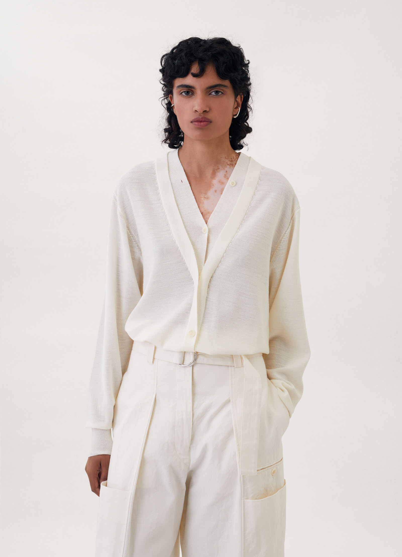 Trompe-l’oeil cardigan in cream knit, model shot, front view loose elongated silhouette