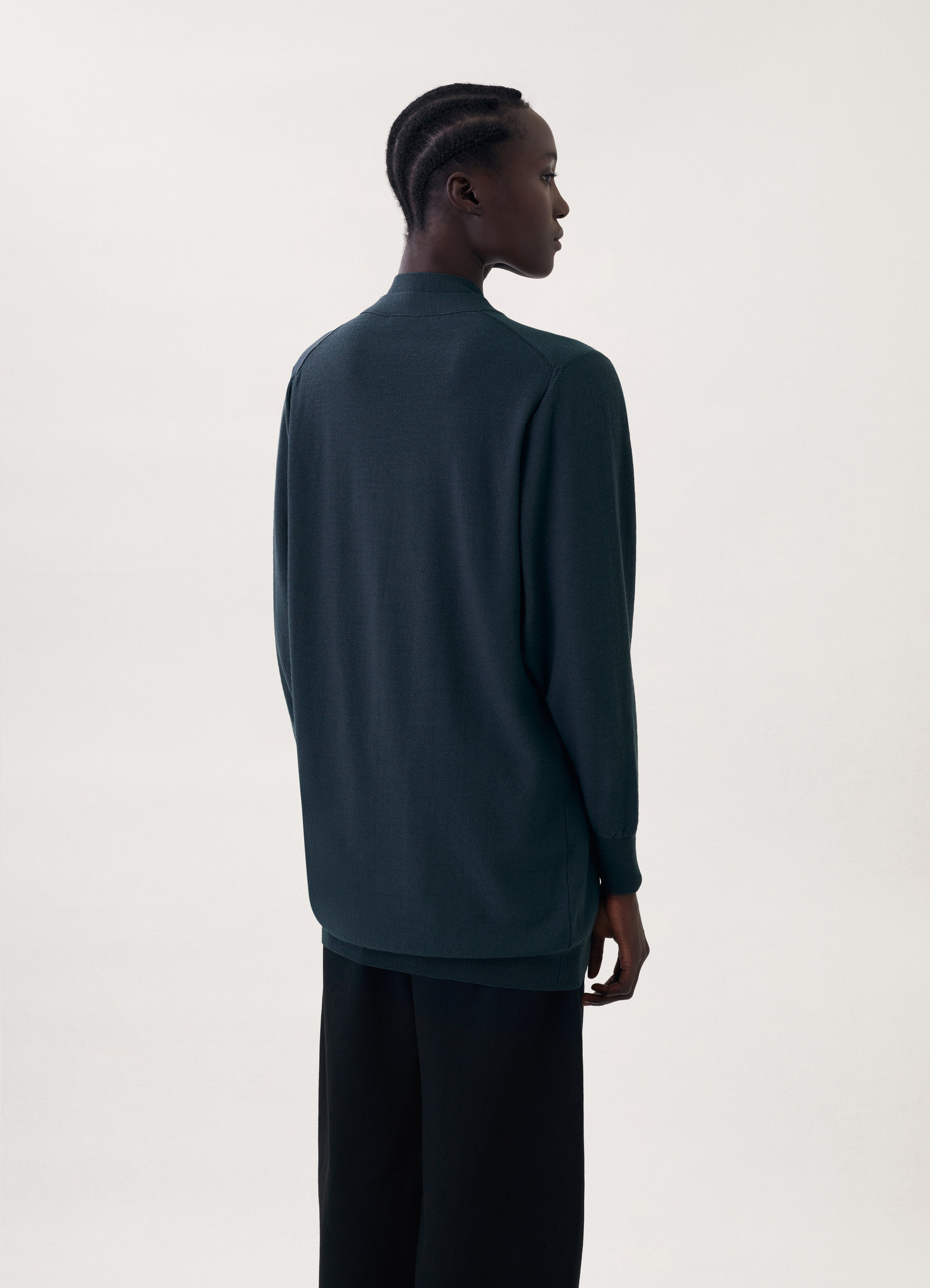 Cardigan with mother-of-pearl in dark green knit, model shot, back view straight sleeves