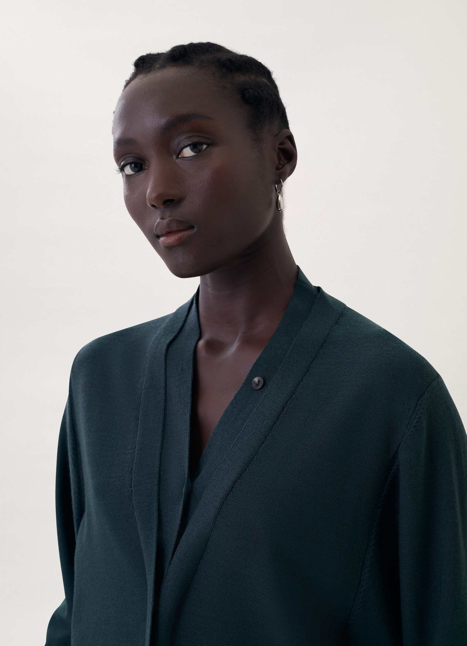 Cardigan with mother-of-pearl in dark green knit, model shot, close-up side view smooth texture, v-neck